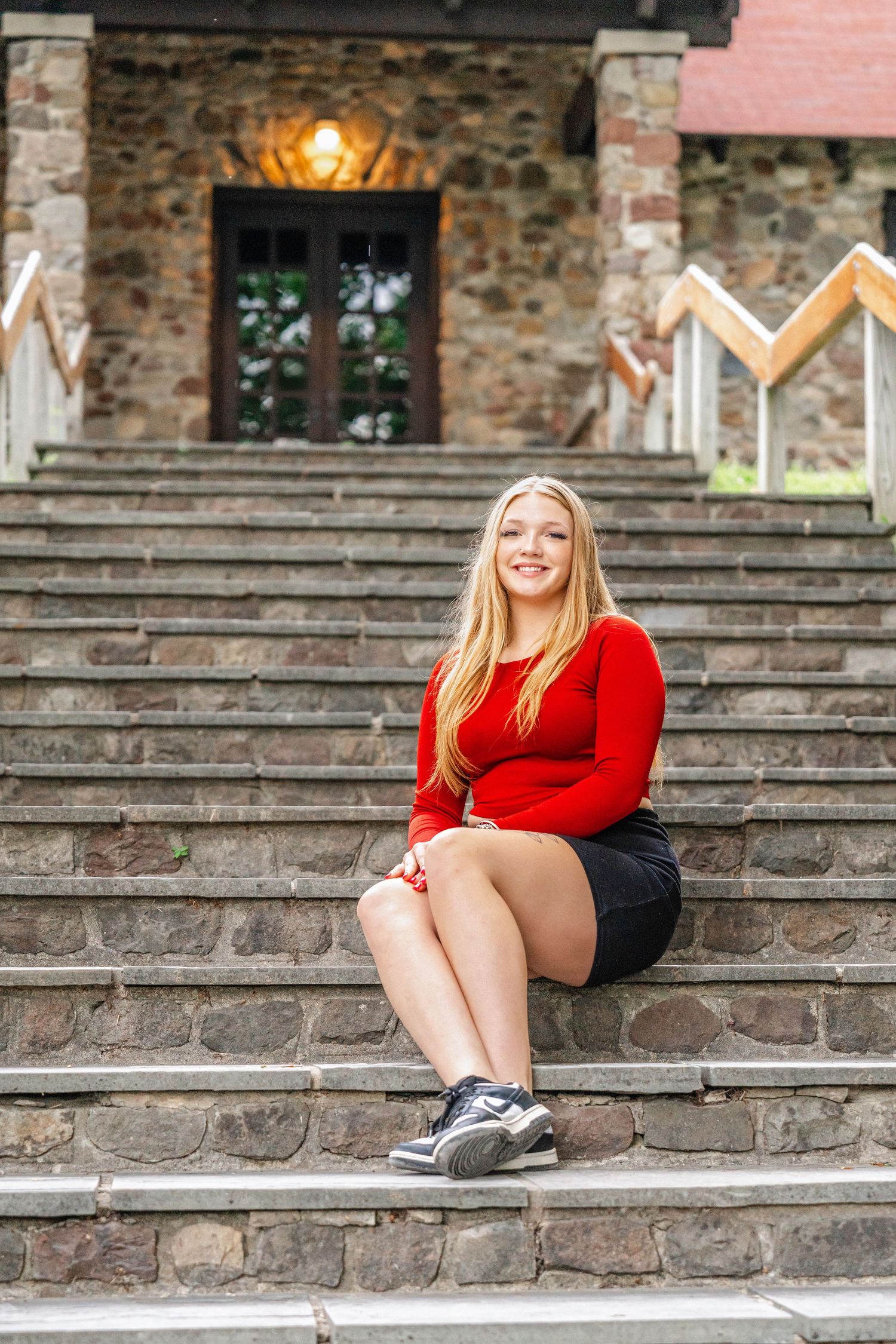 A sequence of casual poses on stone steps with brick walls and warm lighting in the background. Senior photography.
