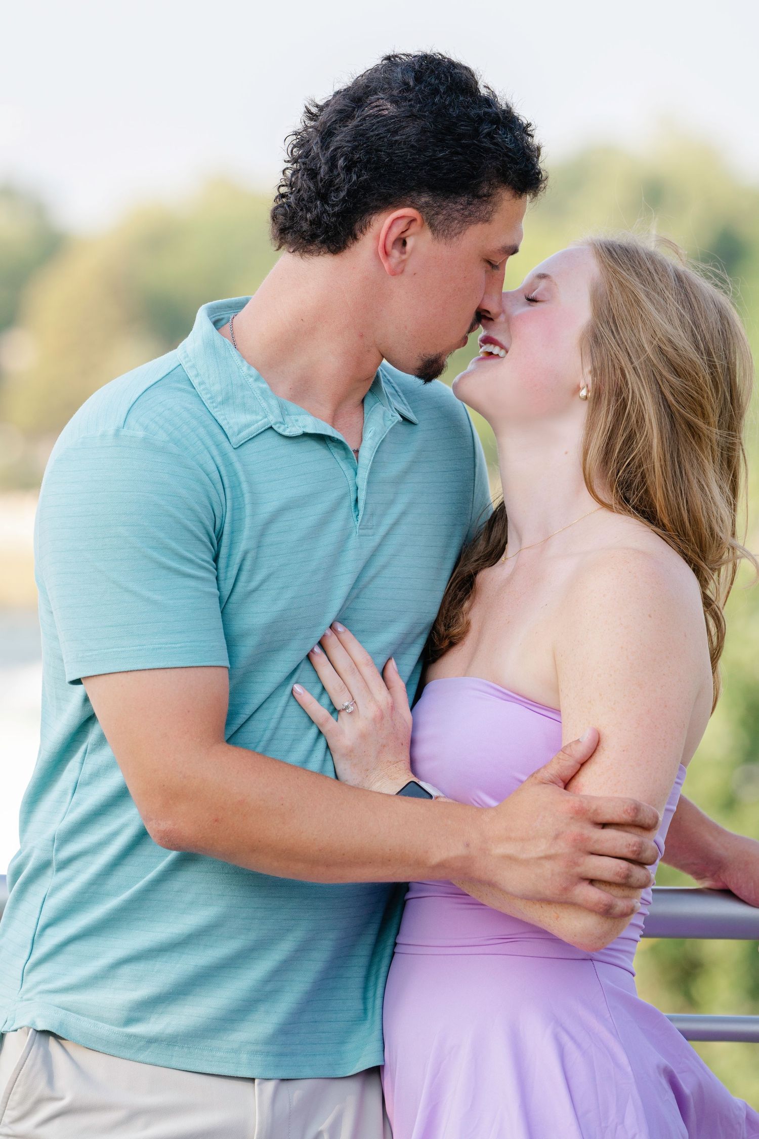 A couple shares intimate moments against a natural outdoor backdrop.