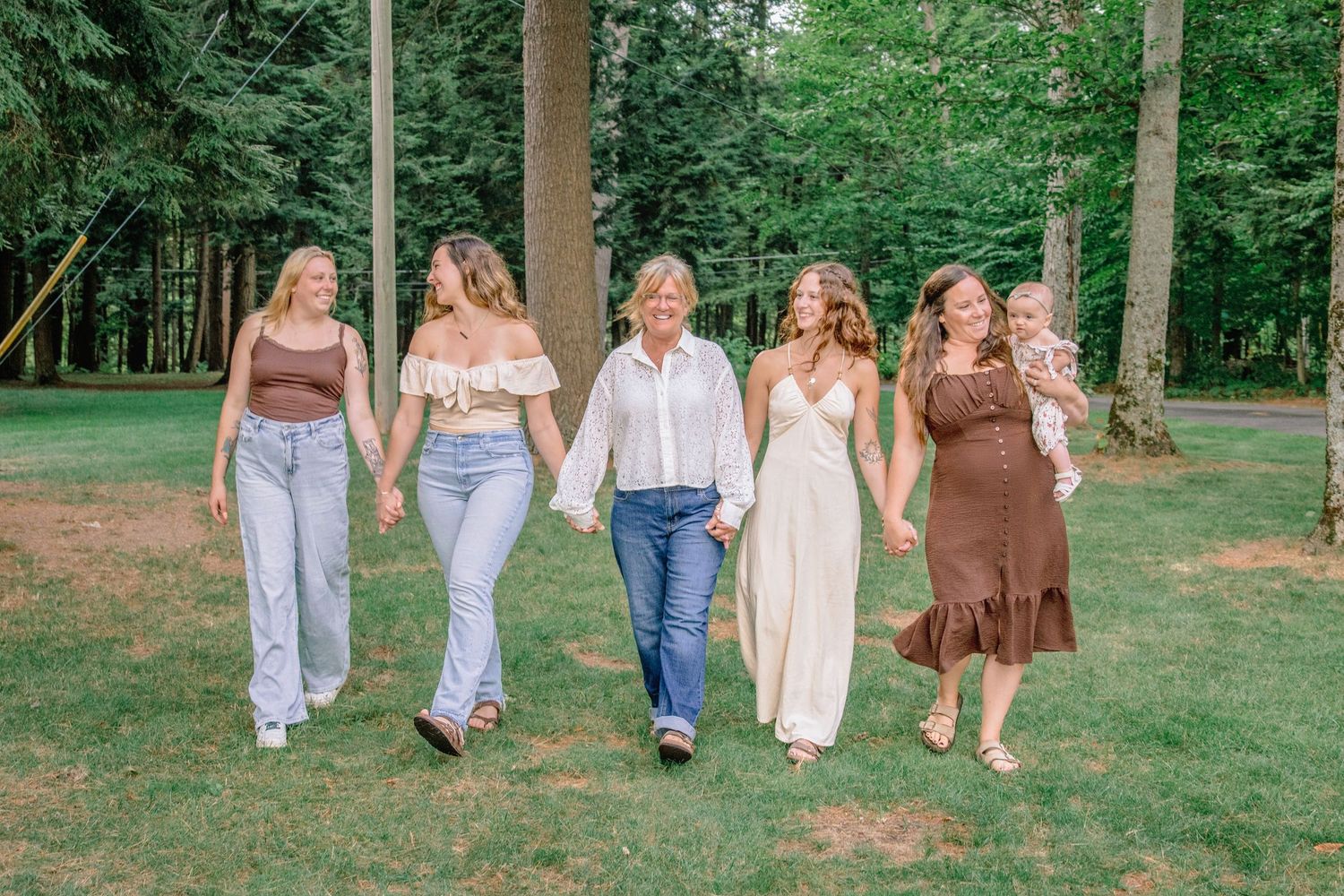 Group walking together in casual attire through a lush green park setting on a sunny day.