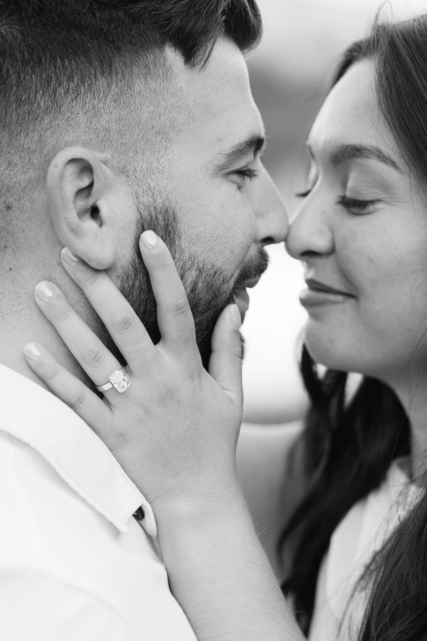 Black and white intimate portraits capture tender moments between a couple during their engagement shoot.