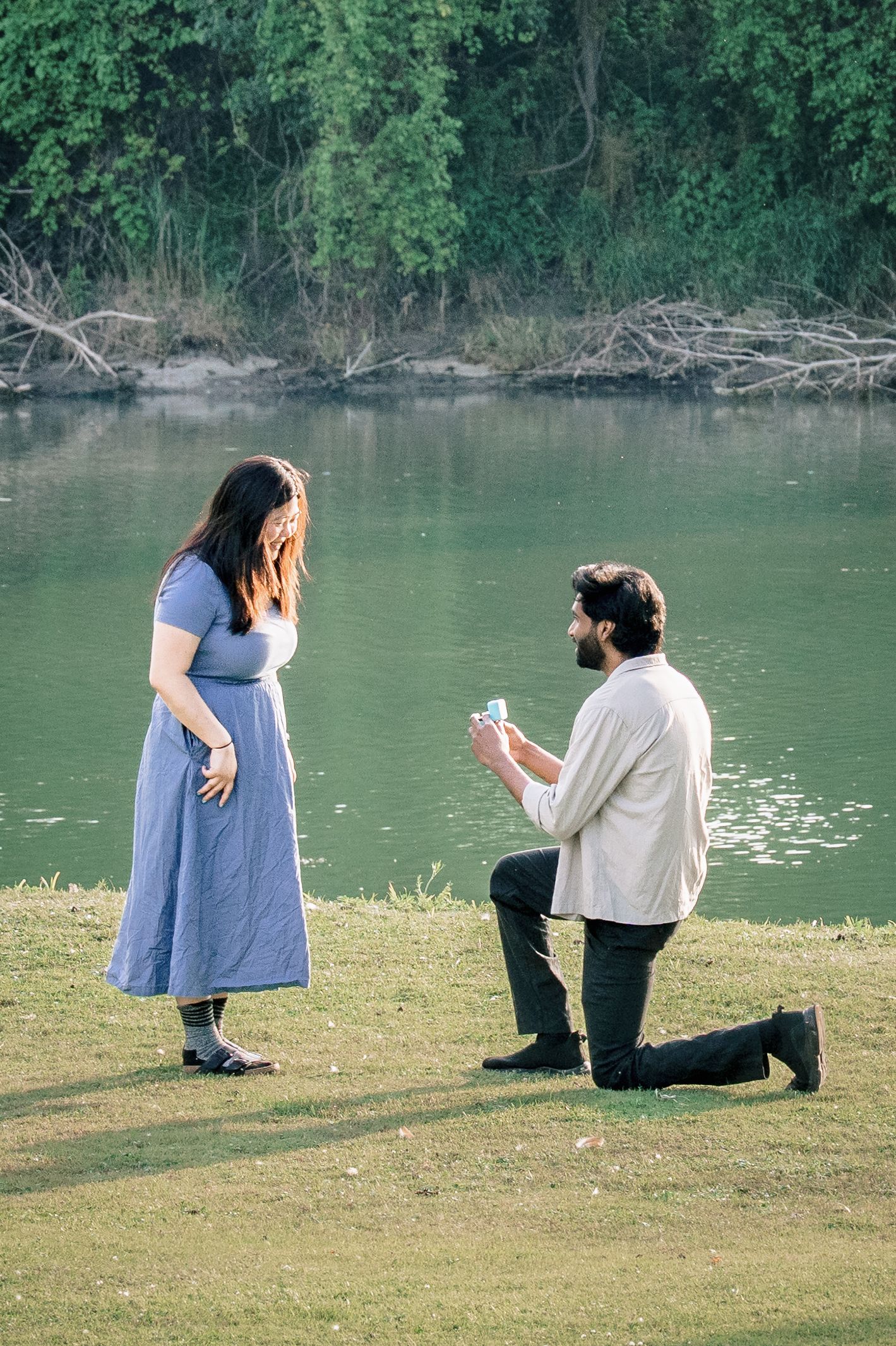 A romantic lakeside proposal scene unfolds in a sequence of photos showing a couple by the water's edge.