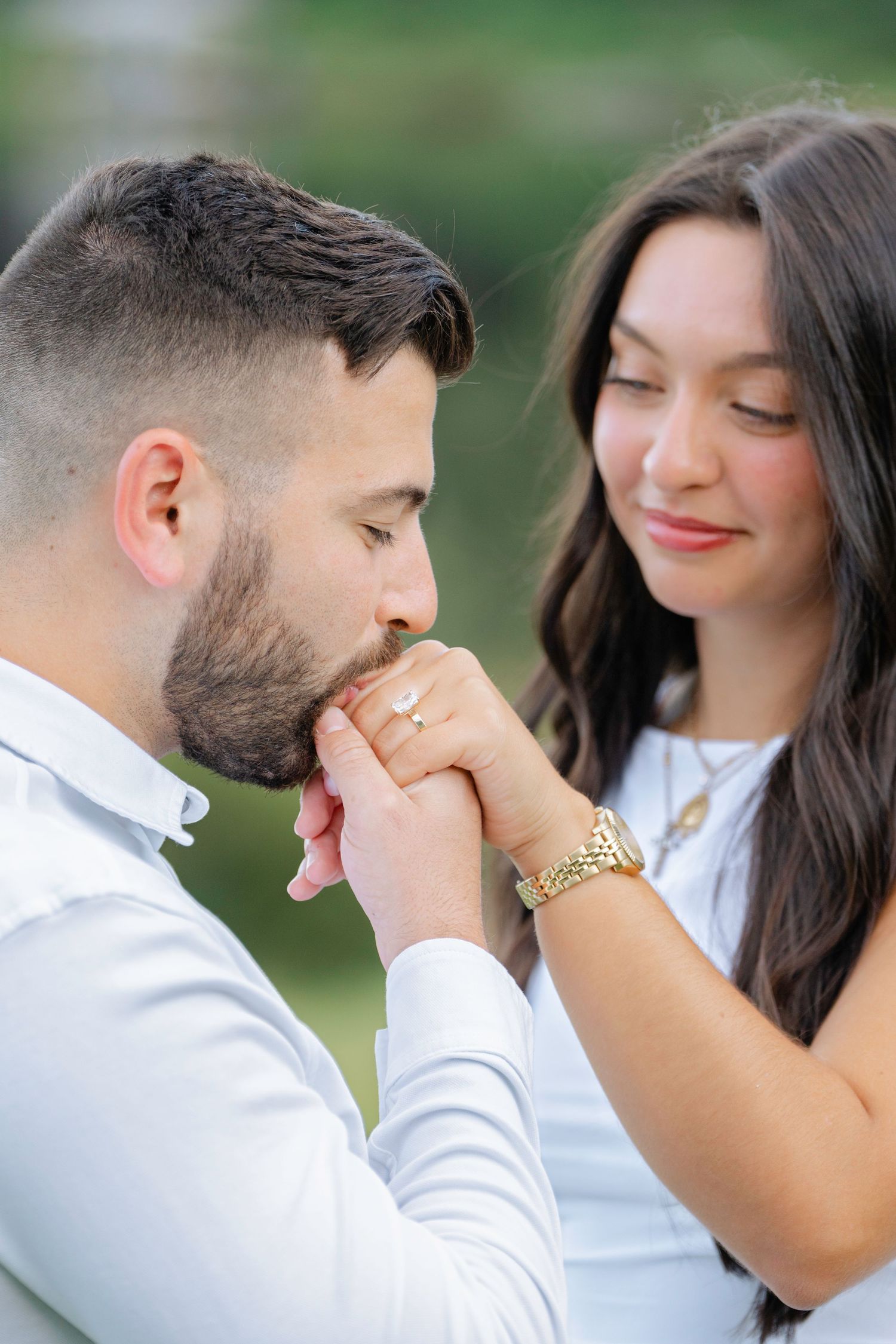 A sweet moment between a couple in white as they share gentle touches and smiles.