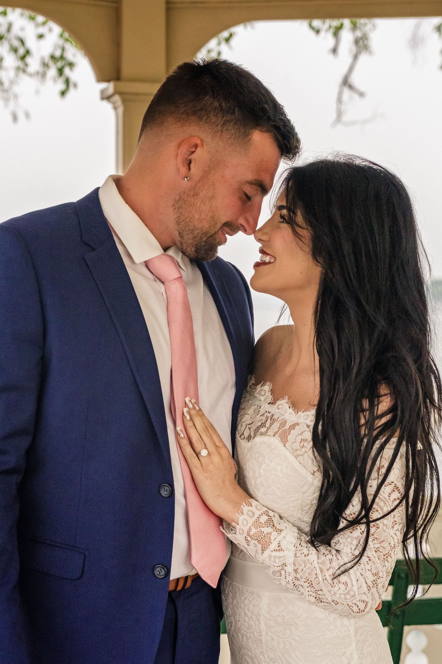 A romantic sequence of wedding photos showing a couple in navy suit and white lace dress sharing intimate moments.