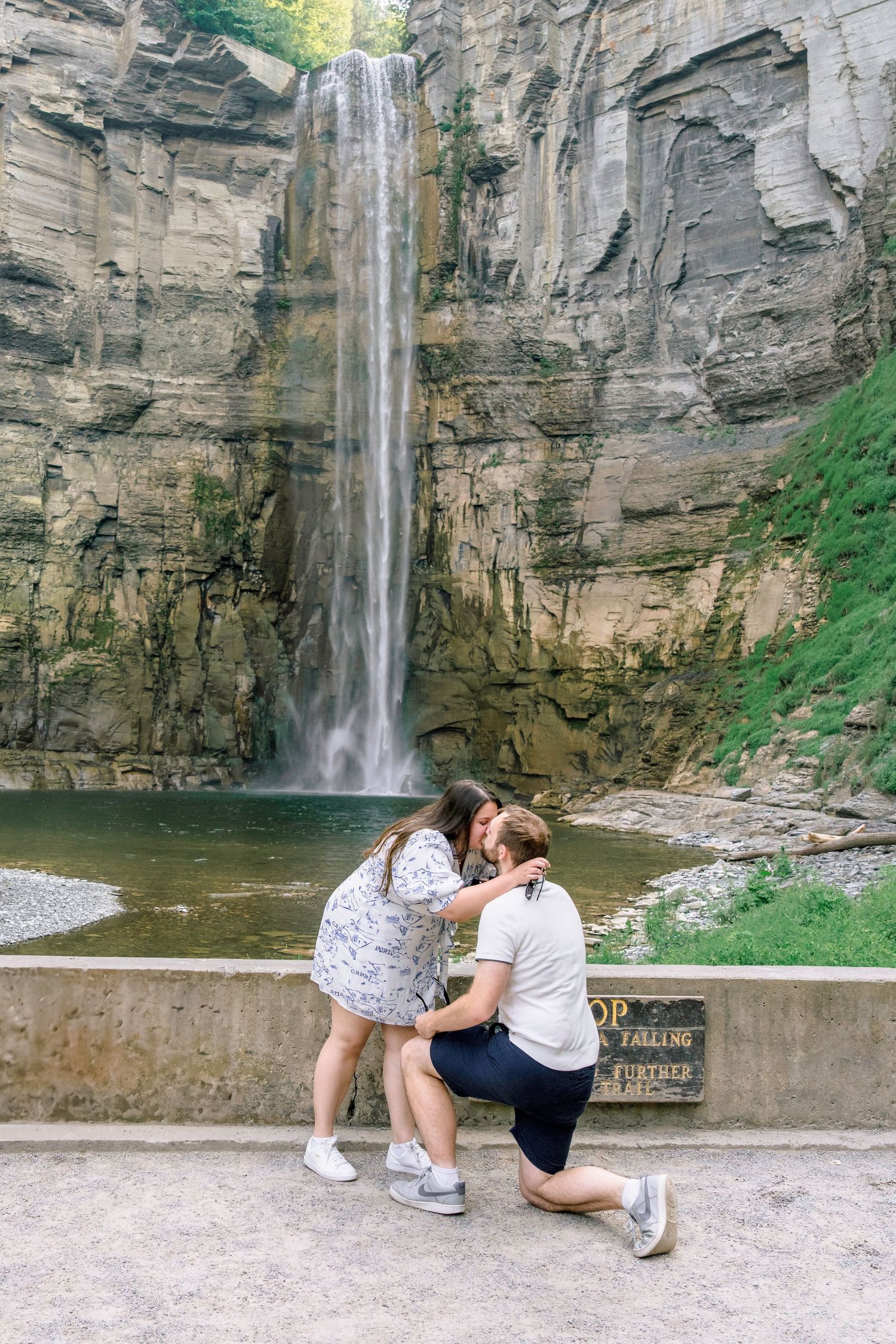 A scenic proposal moment at Taughannock Falls State Park with the majestic 215-foot waterfall cascading in the background.