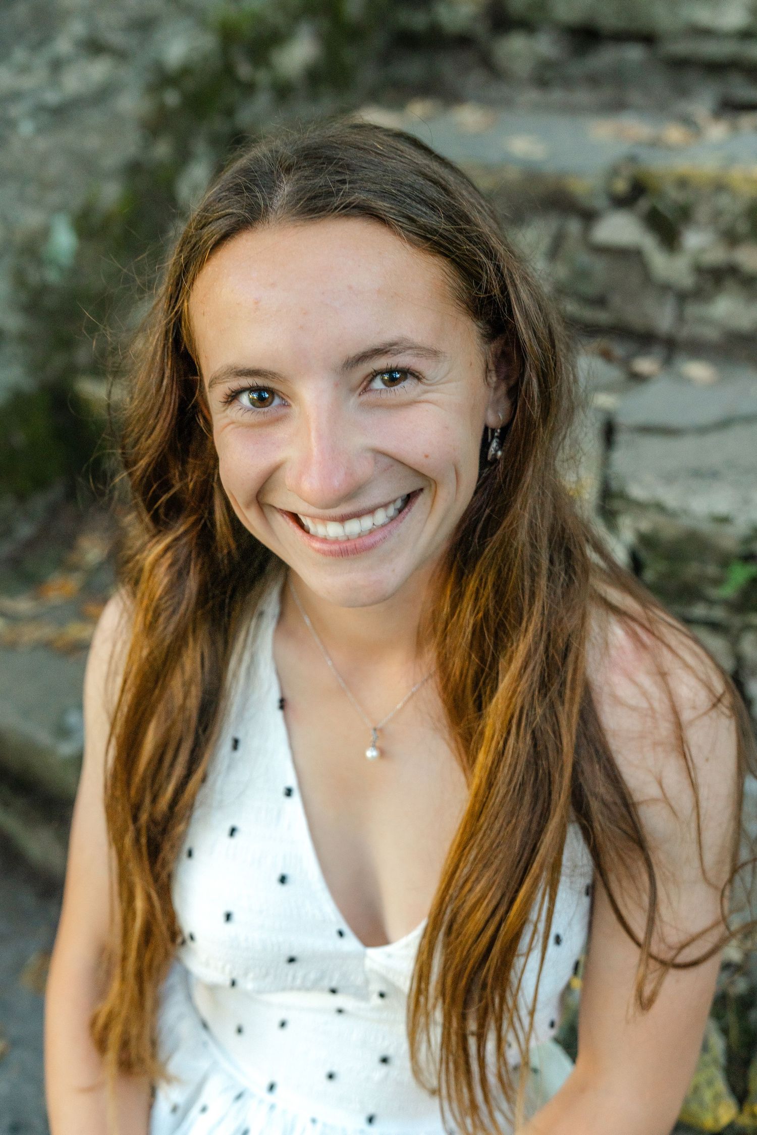 A series of candid outdoor portraits showing someone with long brown hair wearing a white polka dot top against a natural background.