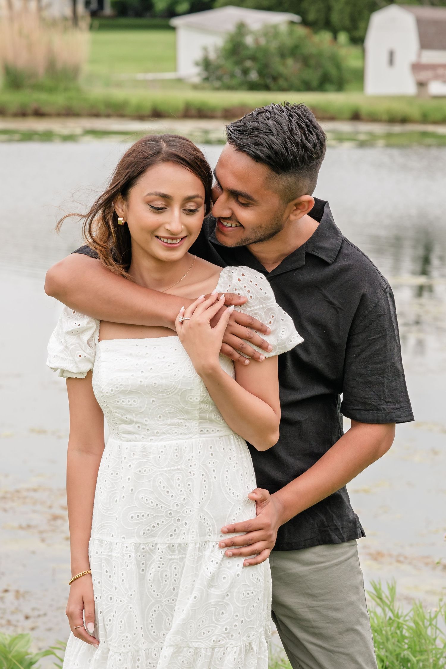 Sweet couple portraits by a lakeside showing affectionate moments in casual summer attire.