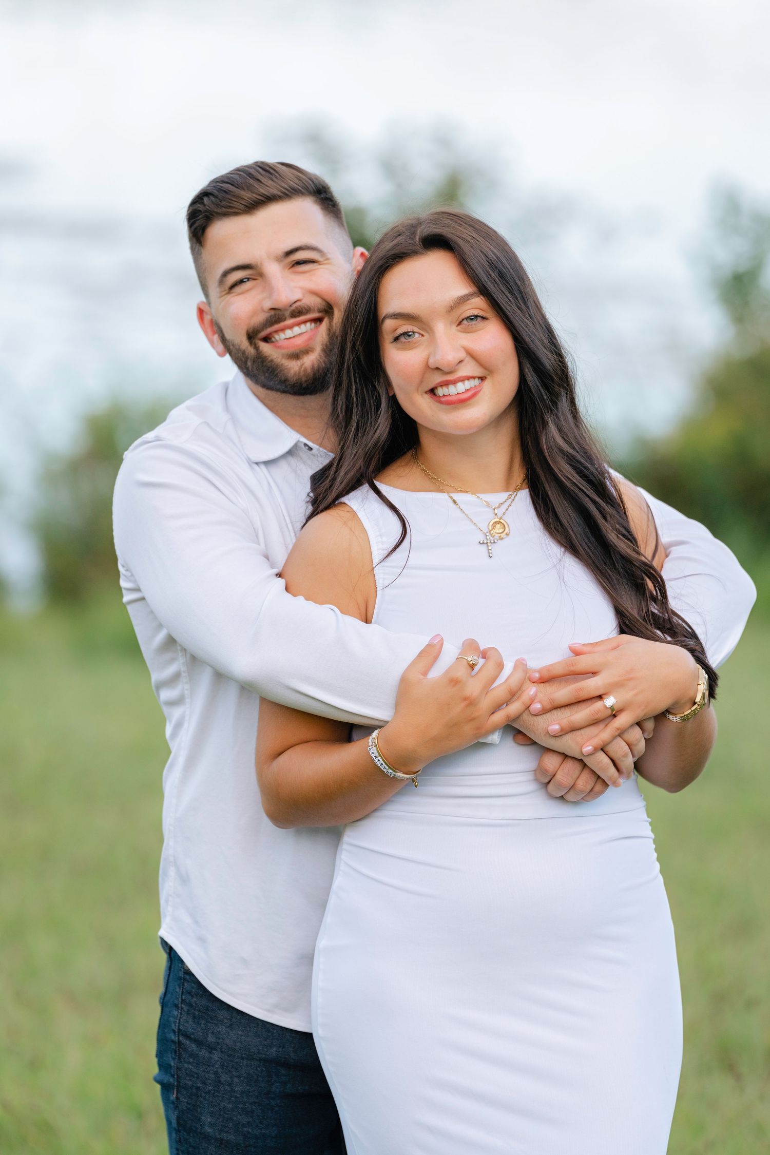 Joyful couple shares intimate moments in white outfits during their outdoor photography session.