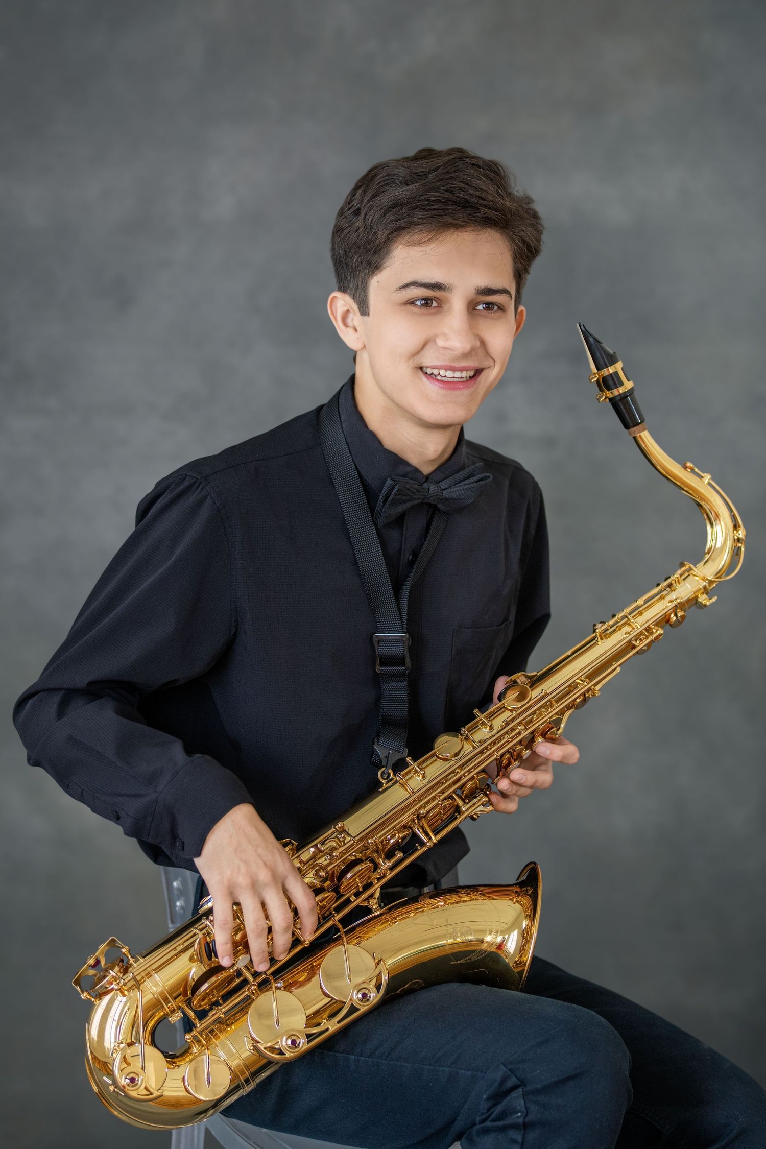 A musician in a dark shirt poses with a golden saxophone in a series of professional studio portraits against a gray backdrop.