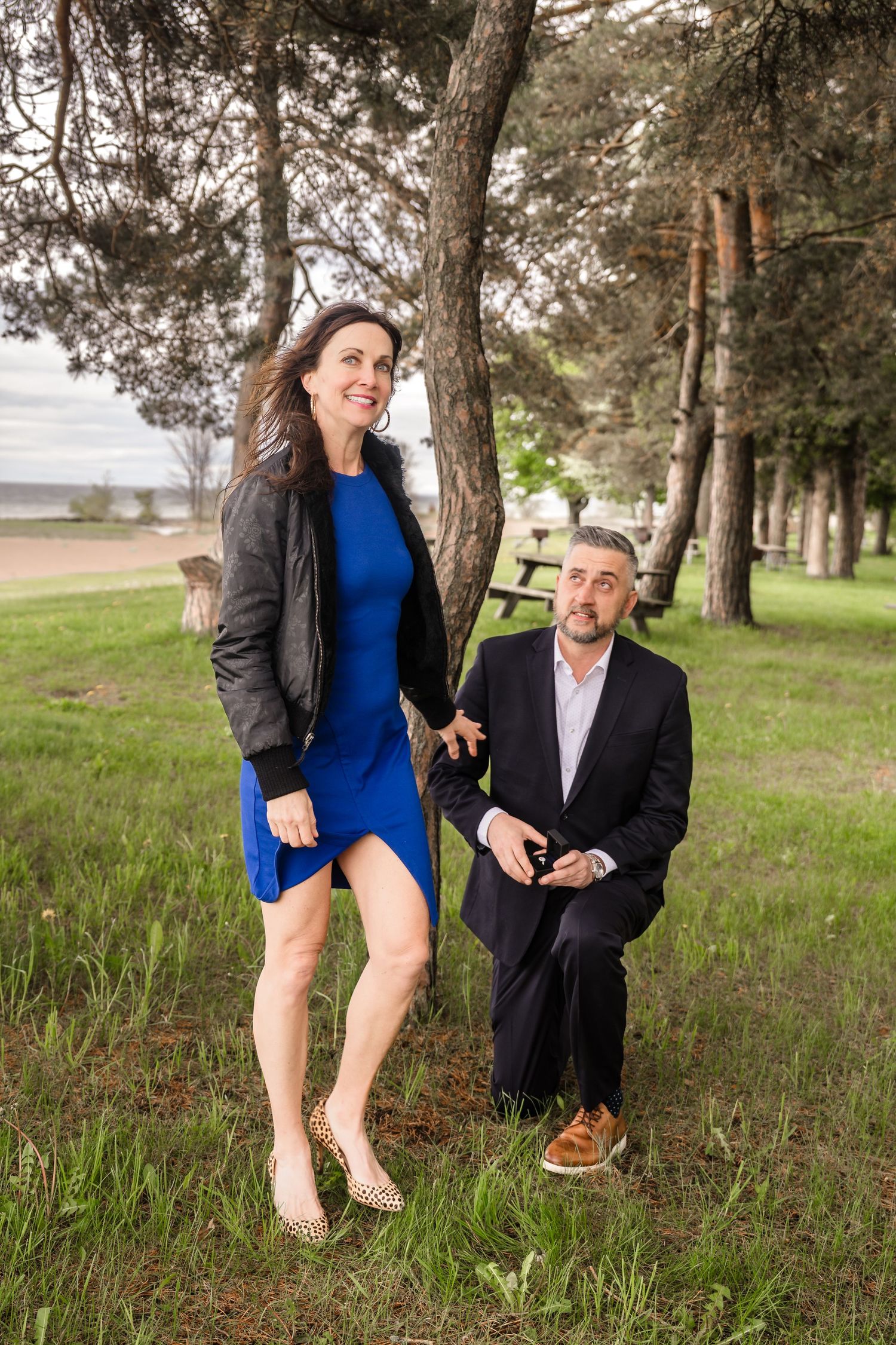 A playful sequence of photos showing a couple enjoying a moment together among pine trees in a grassy area.