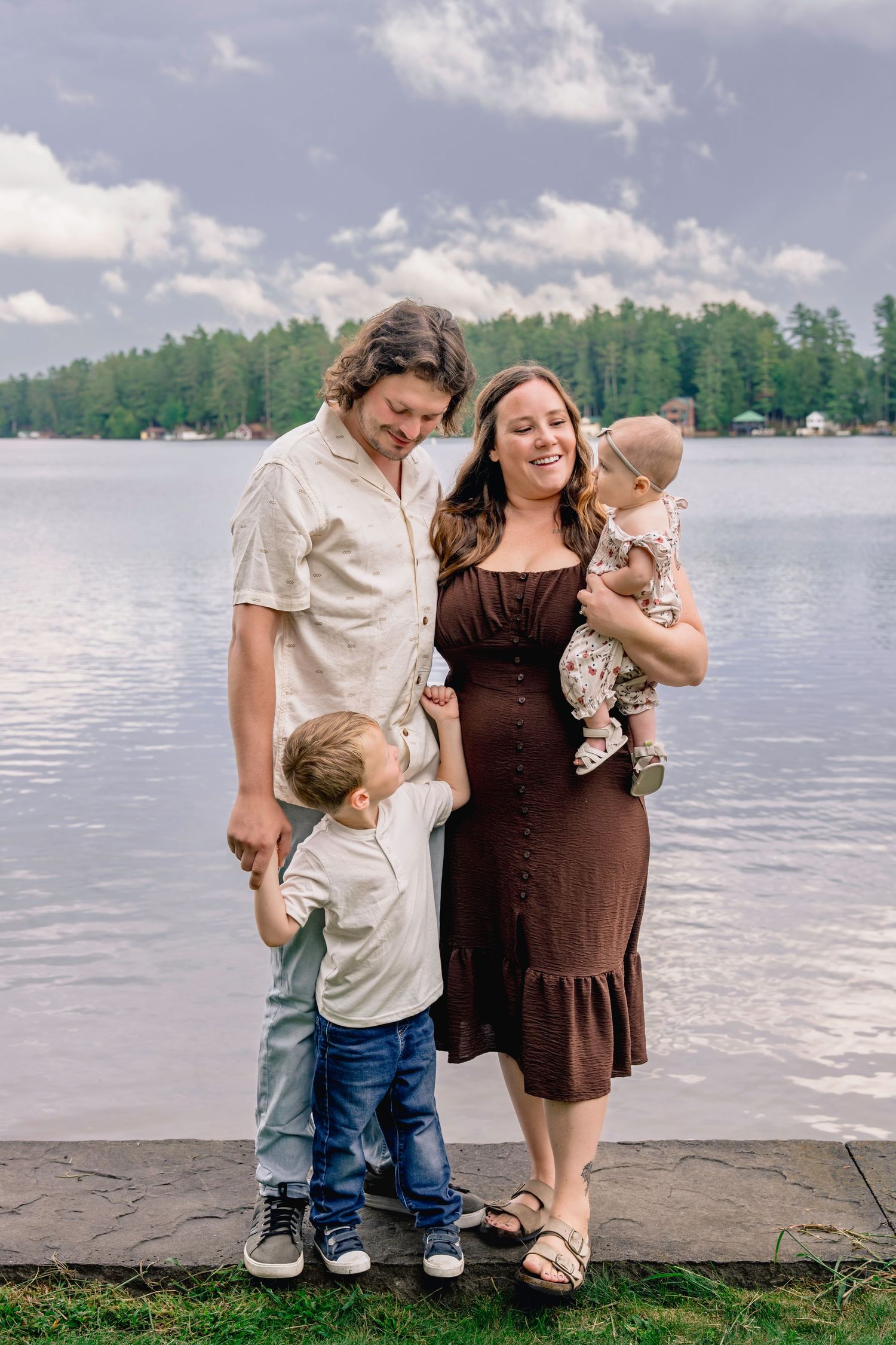 A family enjoying quality time together by a serene lakeside on a beautiful summer day.