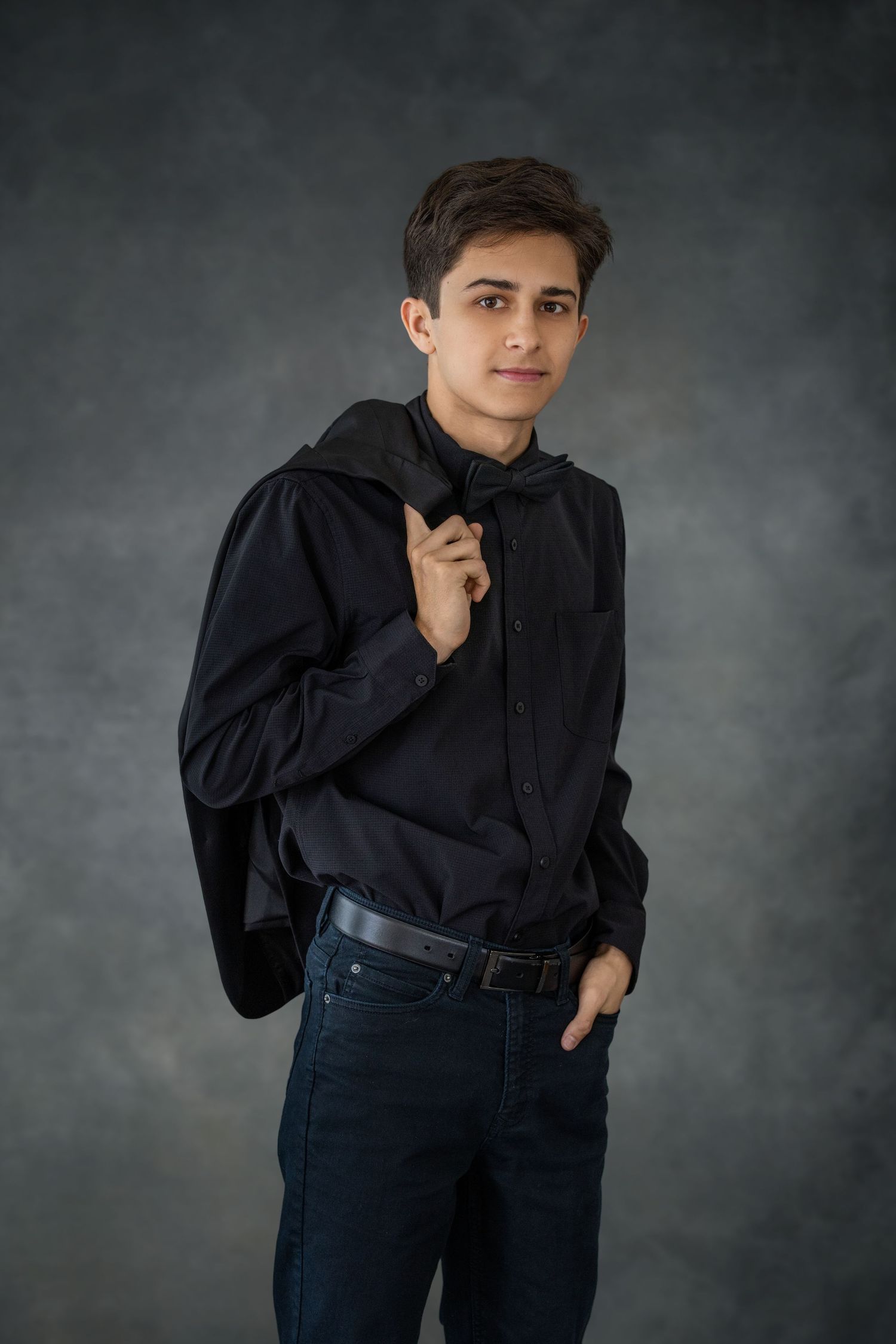 Casual portrait in black button-down shirt showing relaxed poses against dark background. Senior photoshoot.