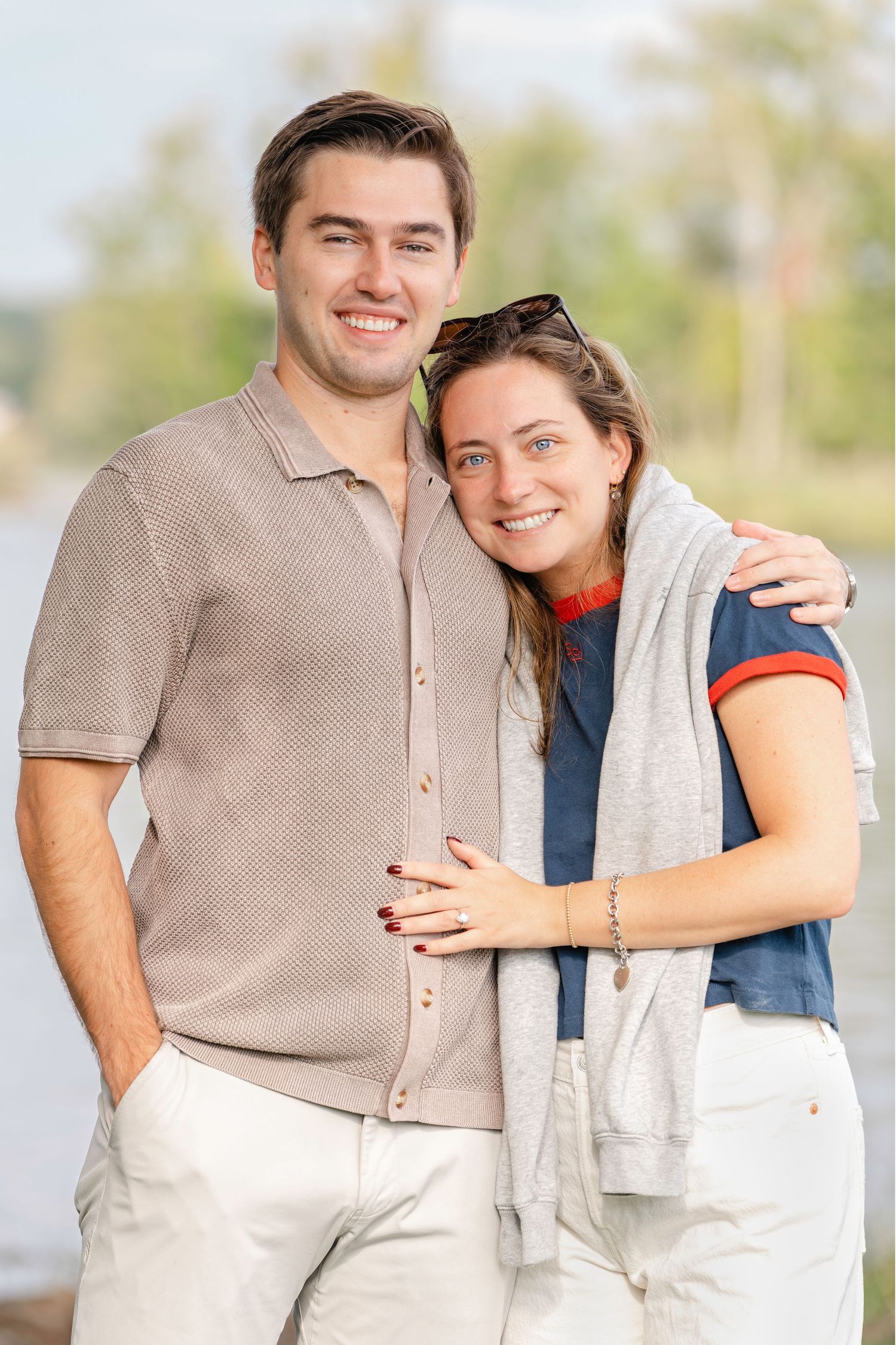 A couple in coordinating beige and white outfits share affectionate moments during an outdoor photo session.