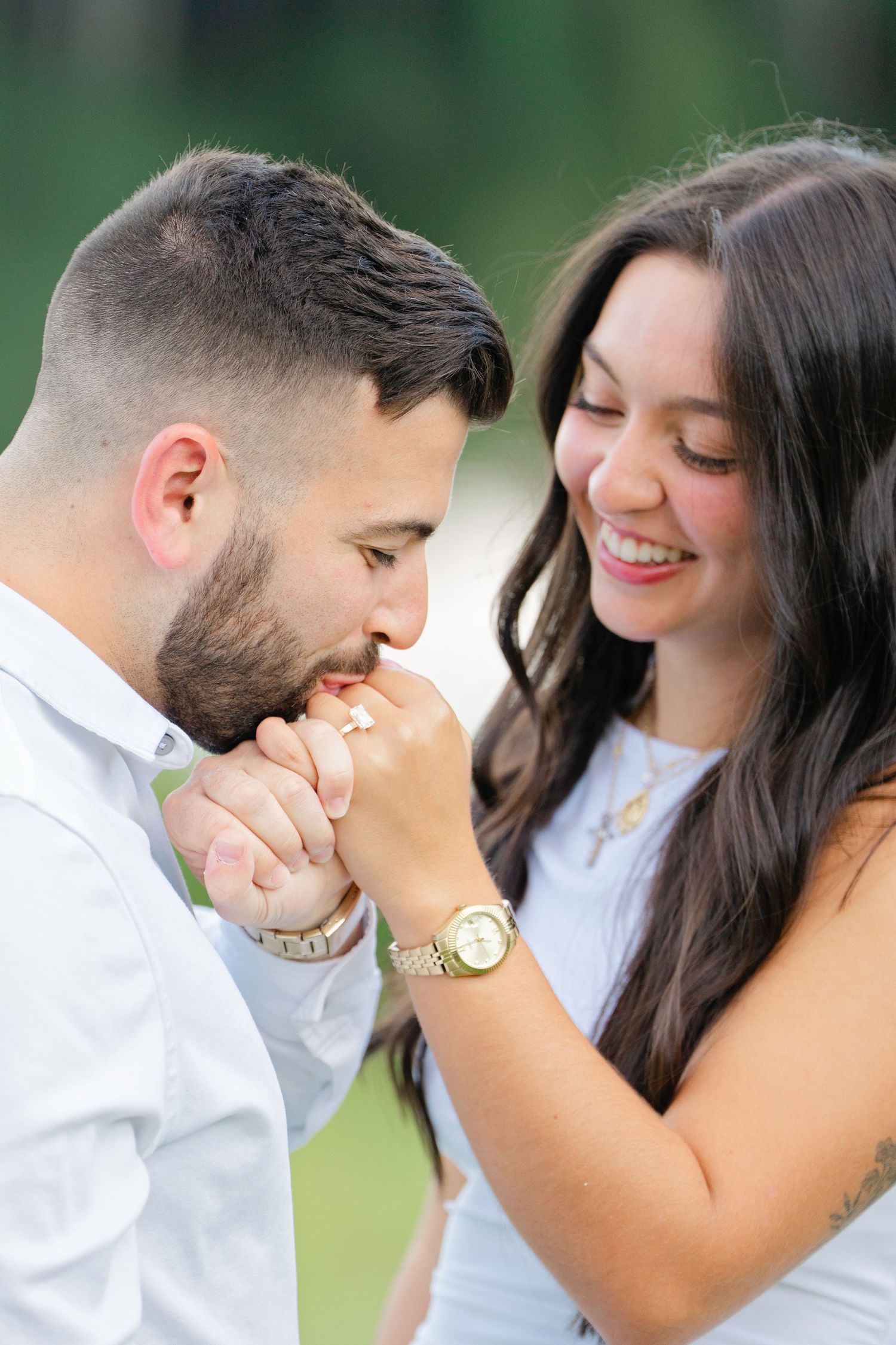 Close-up engagement photos showing tender moments between a couple in white and denim outdoors.
