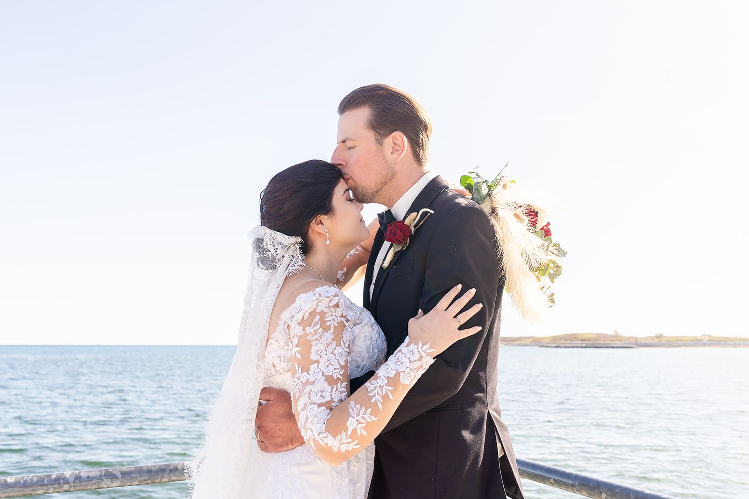 Intimate oceanside wedding portrait with lace dress details and ocean backdrop.