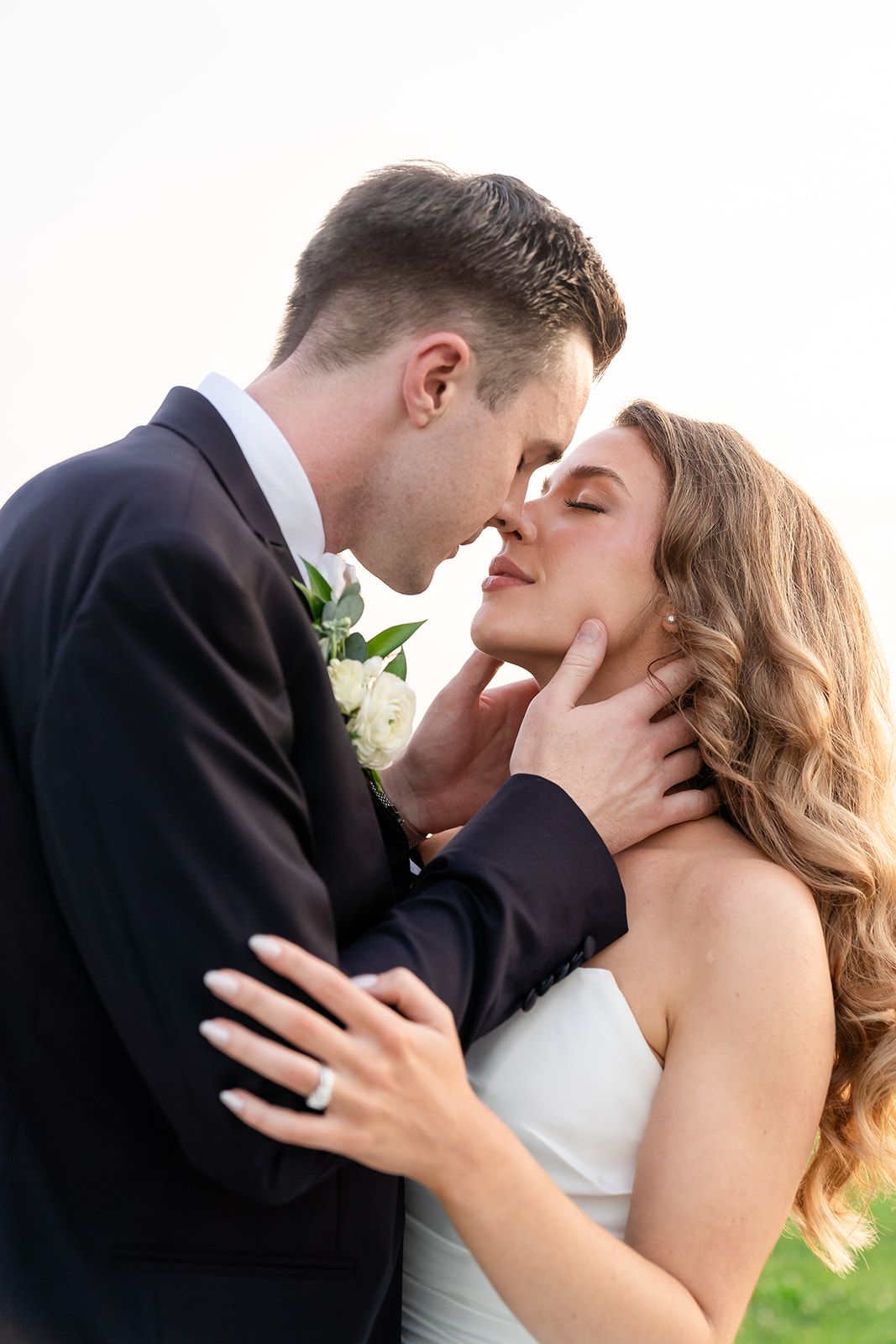 Intimate close-up of newlyweds sharing tender moment outdoors.