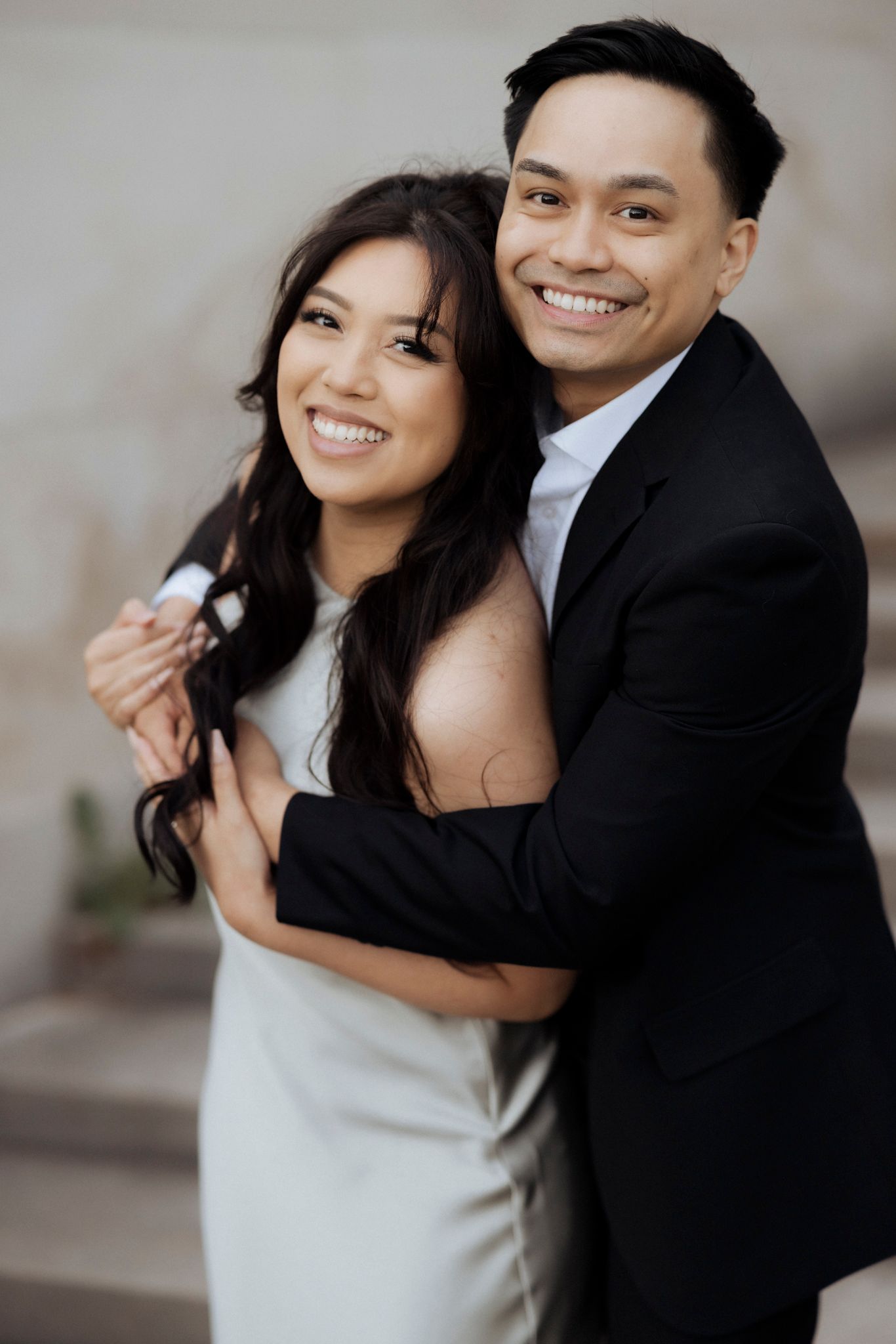 Happy couple in formal attire sharing a joyful moment together.