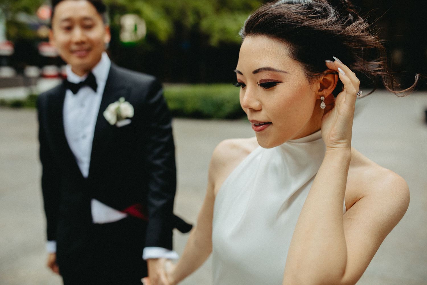 Elegant couple in formalwear posing outdoors during wedding photoshoot.