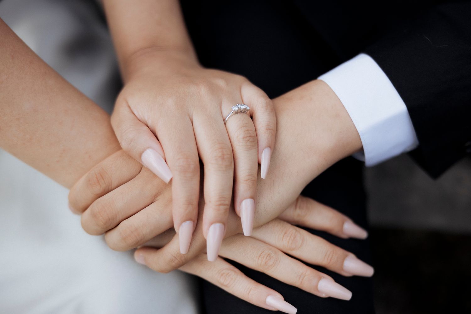 Close-up of hands with engagement ring showing an intimate moment between partners.