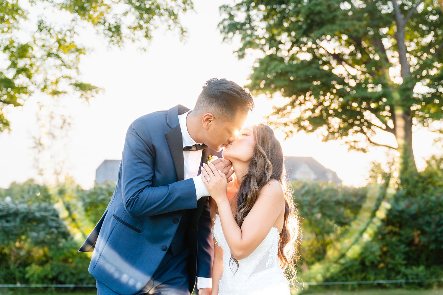 A romantic sunset portrait of newlyweds sharing a tender moment in a garden setting.