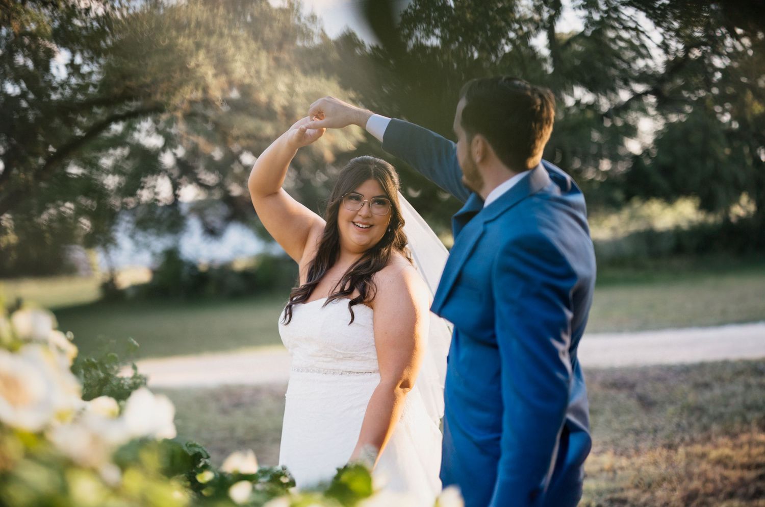 Couple sharing a joyful dancing moment during their outdoor wedding celebration.
