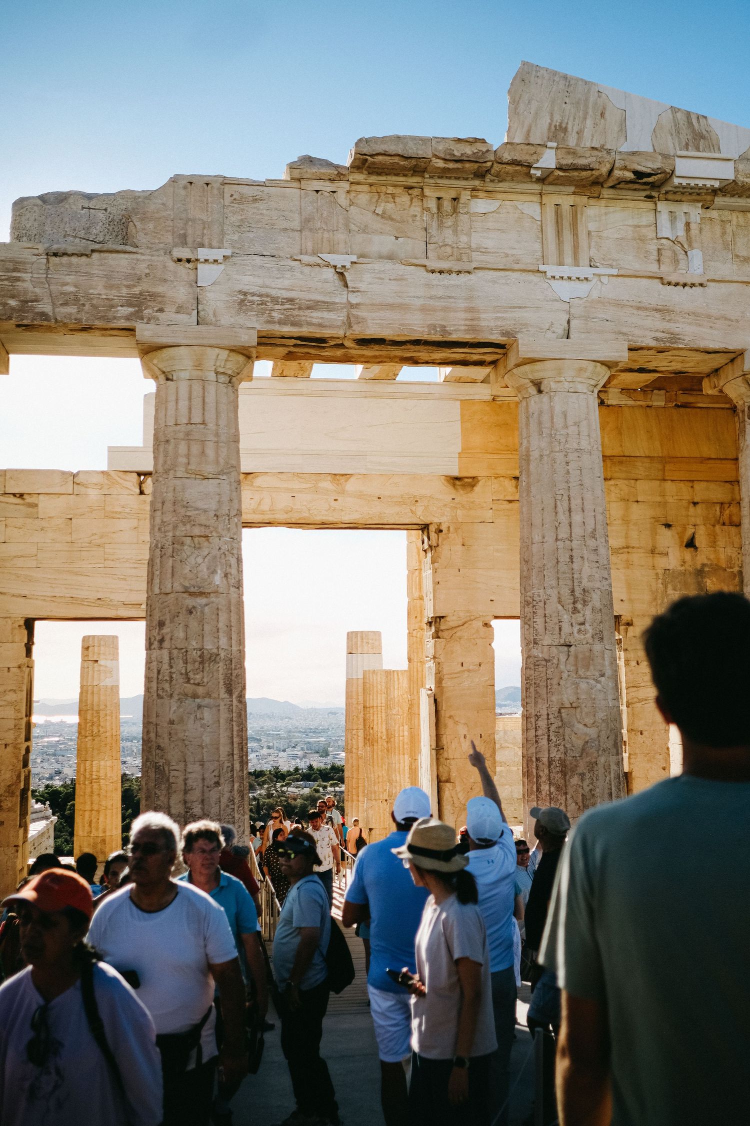 Tourists explore the ancient Propylaea gateway at the Athens Acropolis.