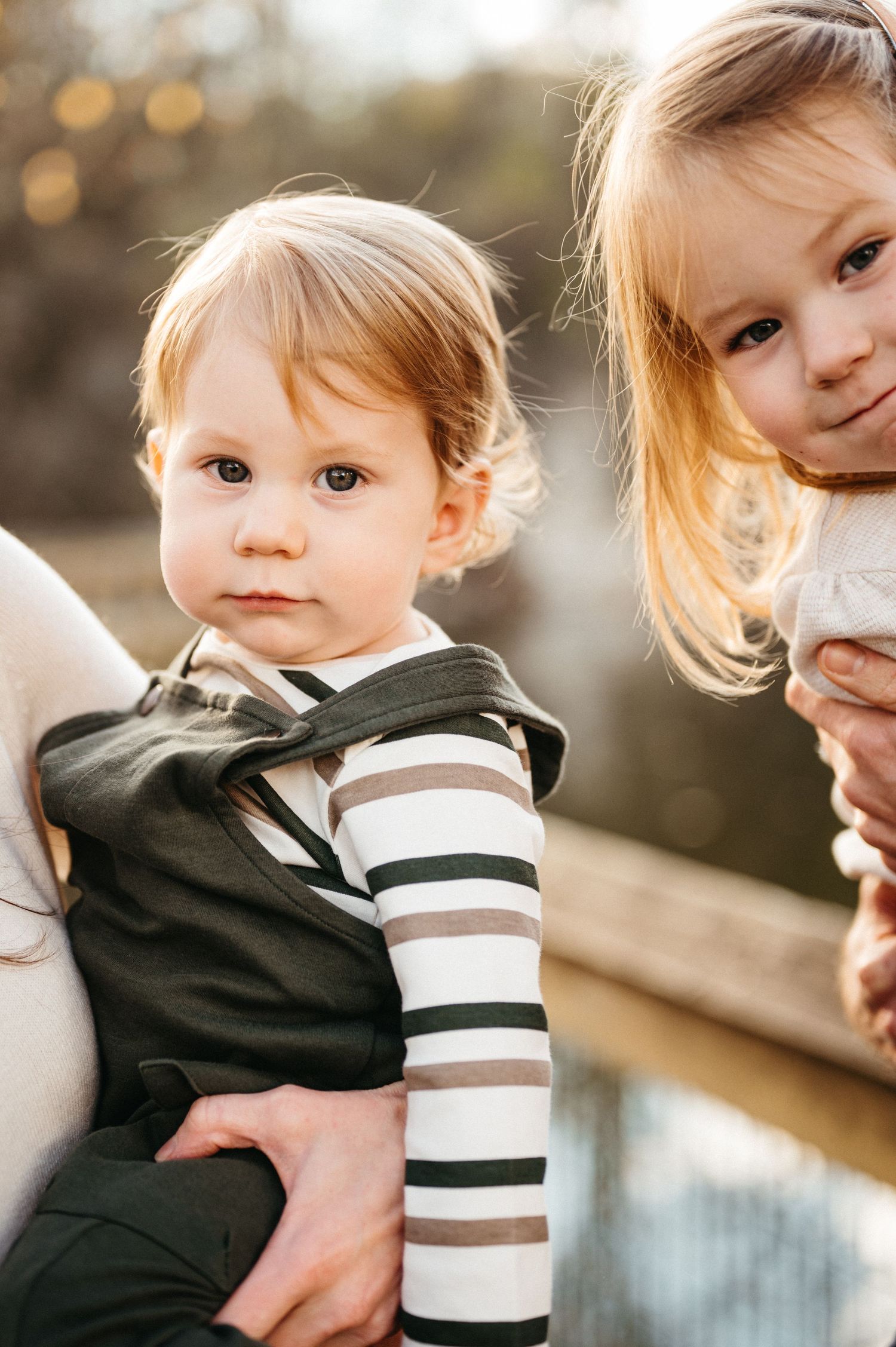 A series of candid outdoor portrait shots showing a young child in a black and white striped outfit against a soft bokeh background.