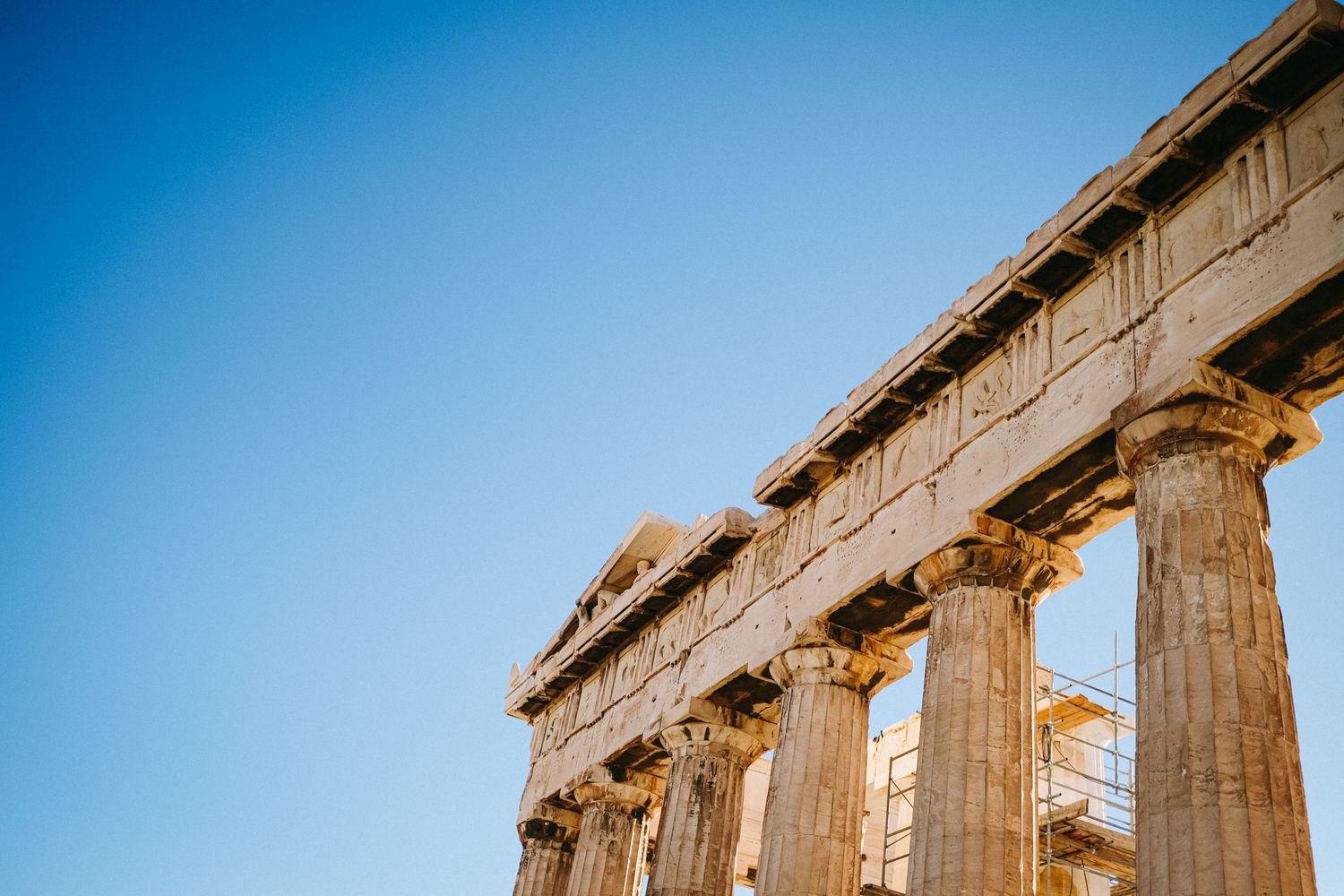 Close-up view of the Parthenon's Doric columns against a vivid blue sky in Athens.