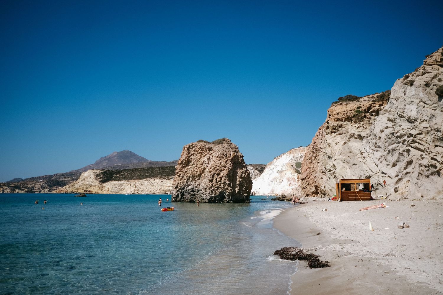 Beautiful rocky beach cove with white limestone cliffs and crystal clear blue waters.