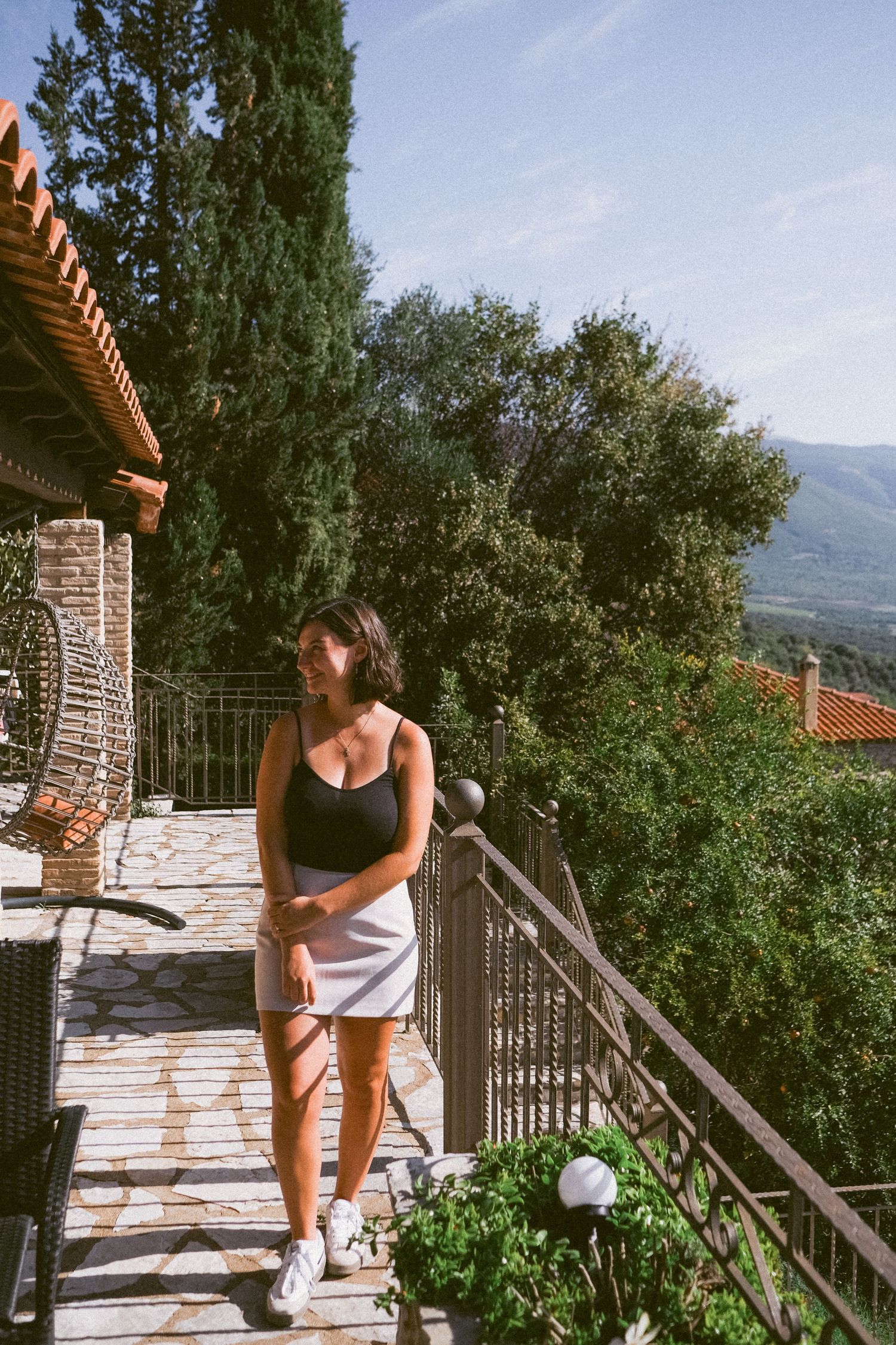 A summer deck view of a mountain villa with lush greenery and scenic landscape.