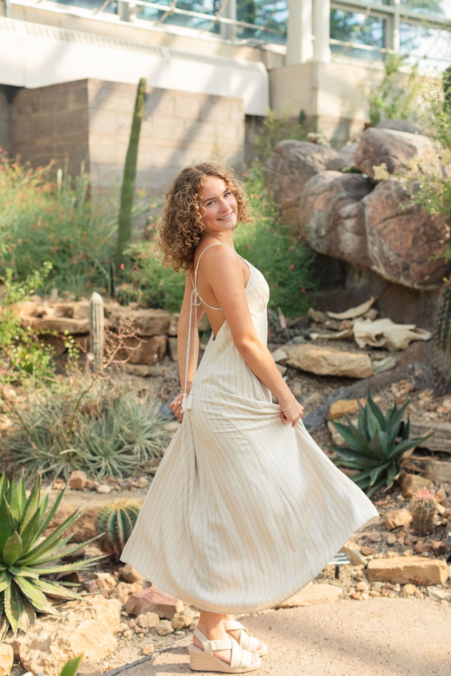 High school senior smiling during her St. Louis senior portraits at the Botanical Gardens. Authentic senior photography by Faith’s Flicks.