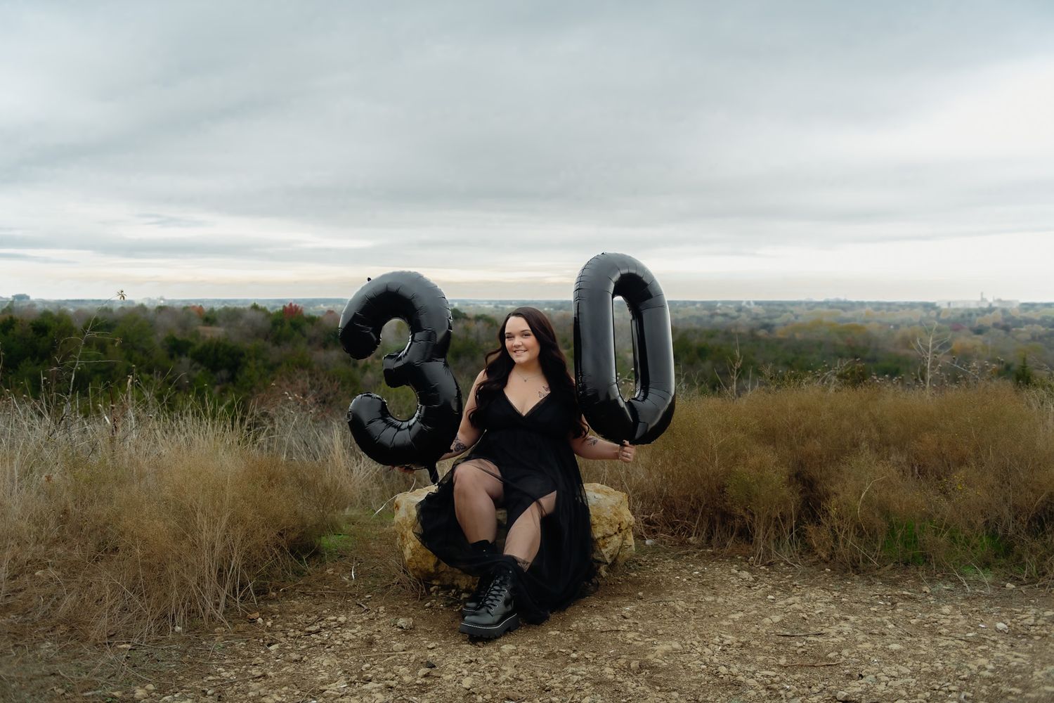 Series of dynamic poses with black balloons in natural outdoor setting at dusk.