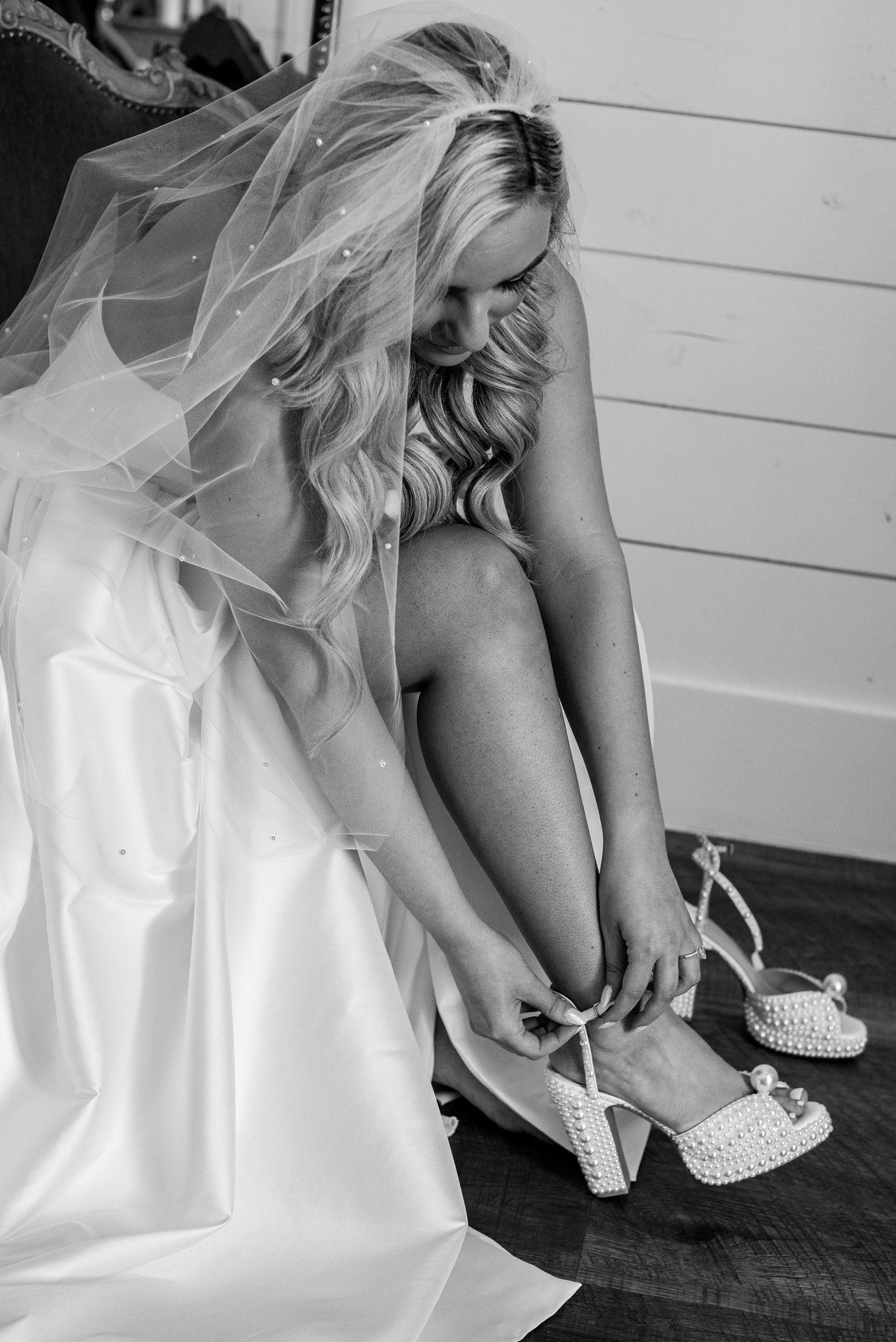 Black and white image of bridal preparations showing white dress and shoes.
