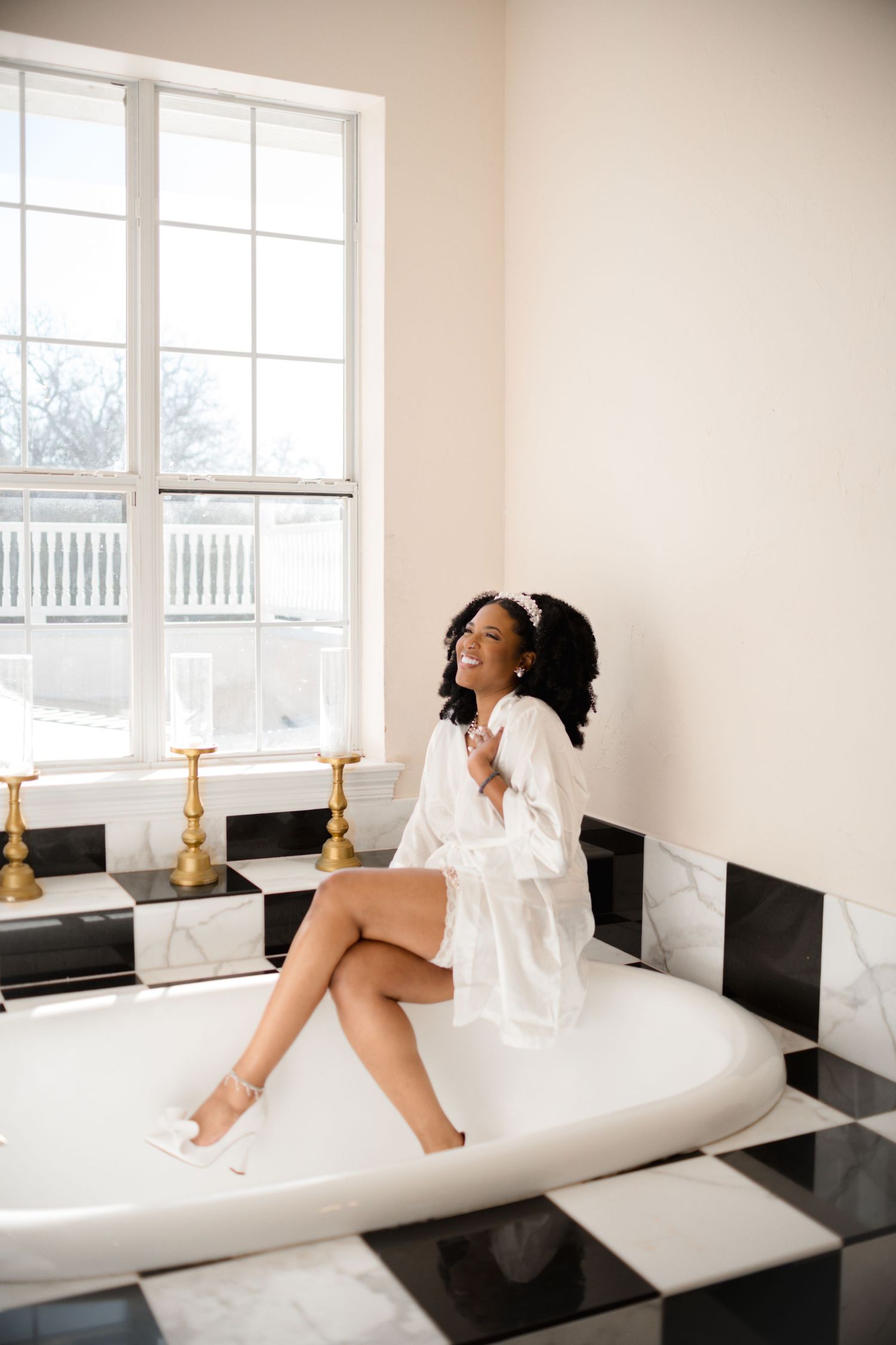Boudoir photography session in bright white room with natural window light.
