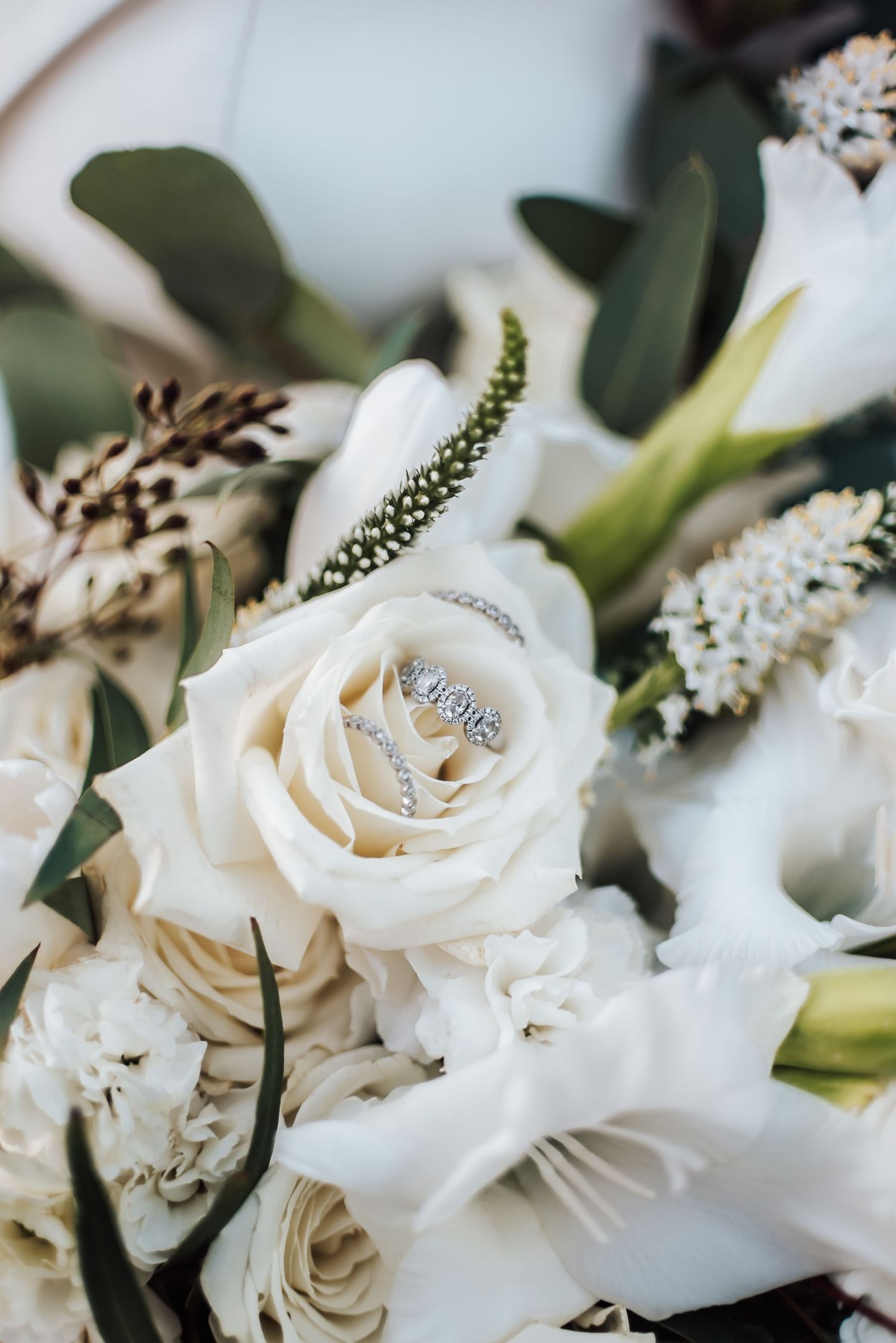 Close-up of white roses and delicate floral arrangements with greenery.