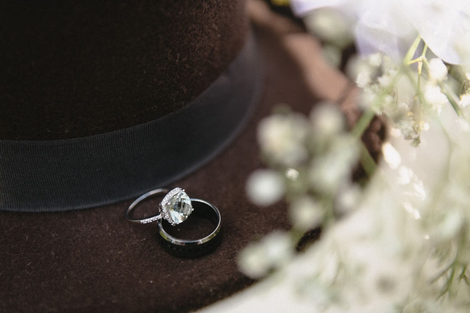 Close-up detail shot of diamond engagement ring with soft bokeh background.
