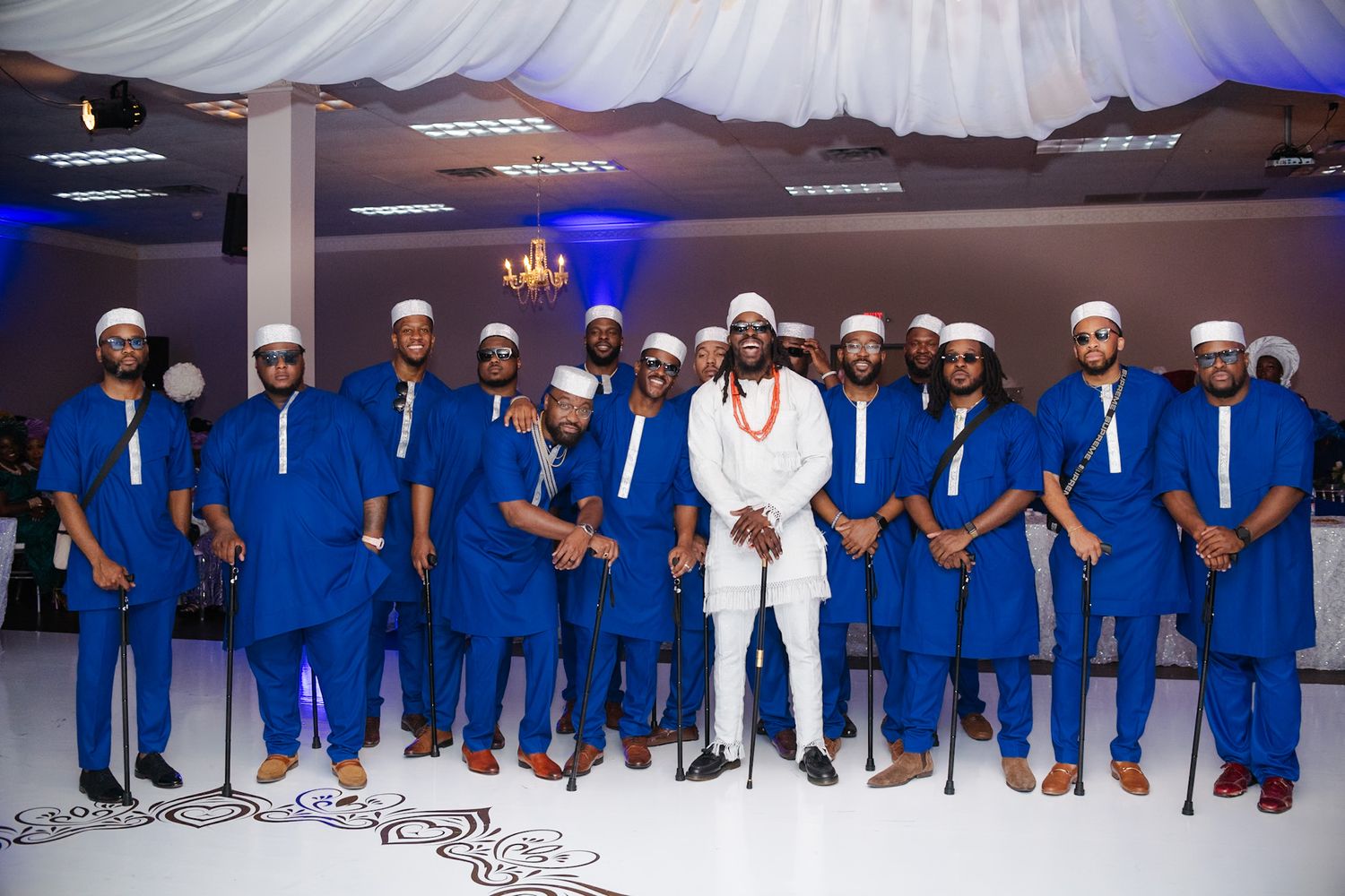 A group wearing coordinated royal blue and white outfits poses together at a formal event.