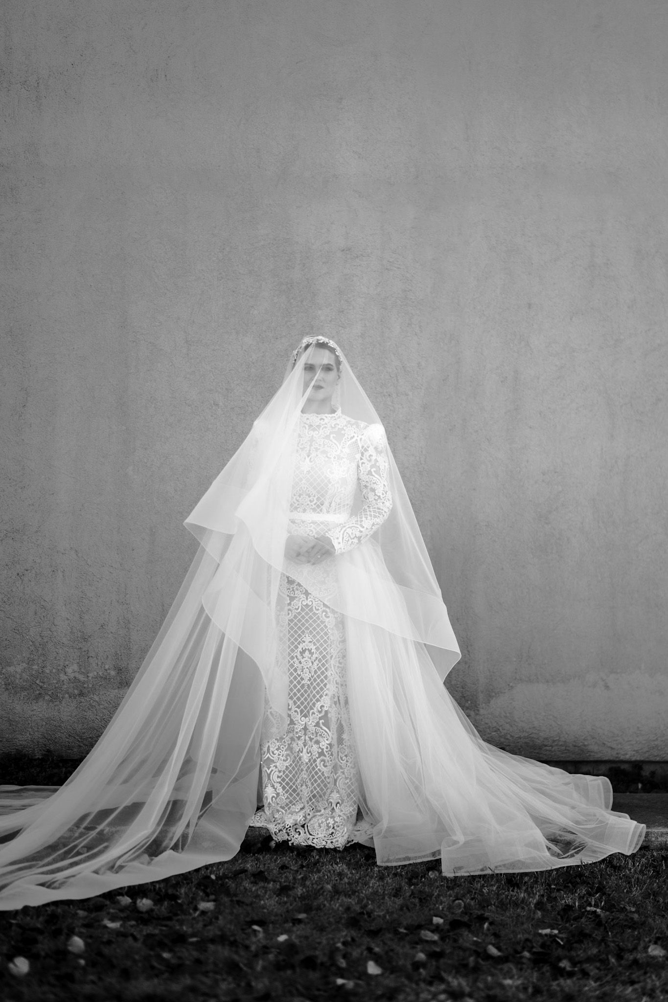 Artistic black and white photo series of a flowing white wedding dress with lace details.