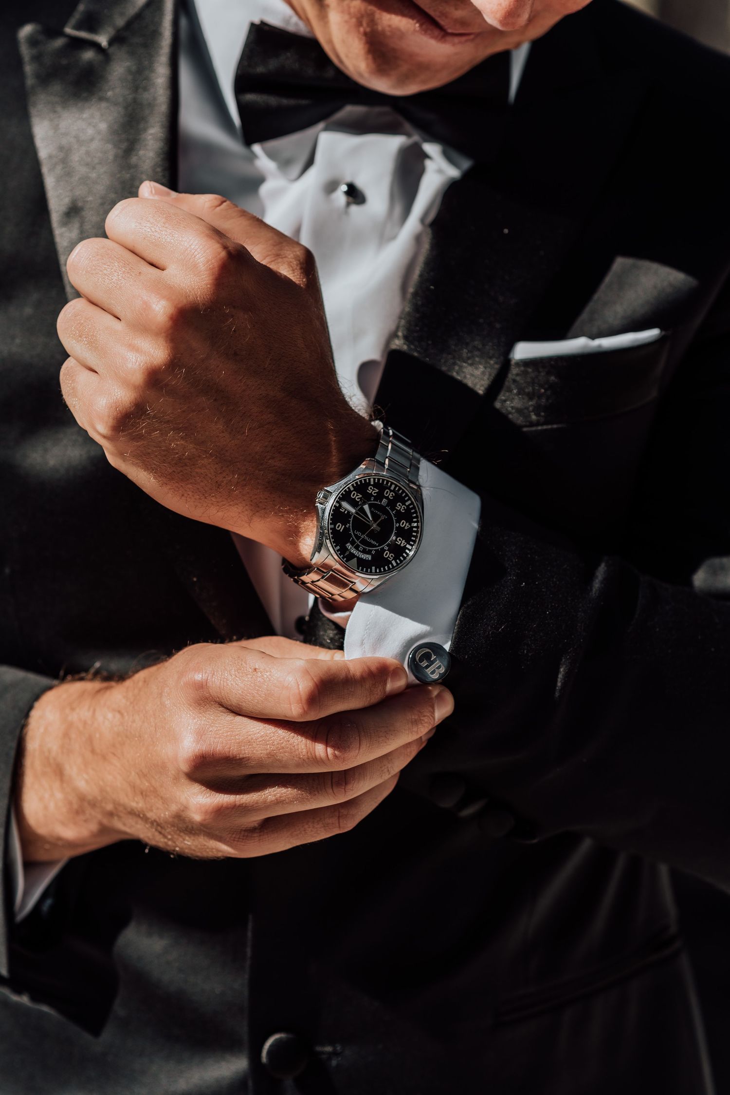 Detail shots of hands adjusting formal watch and cufflinks.