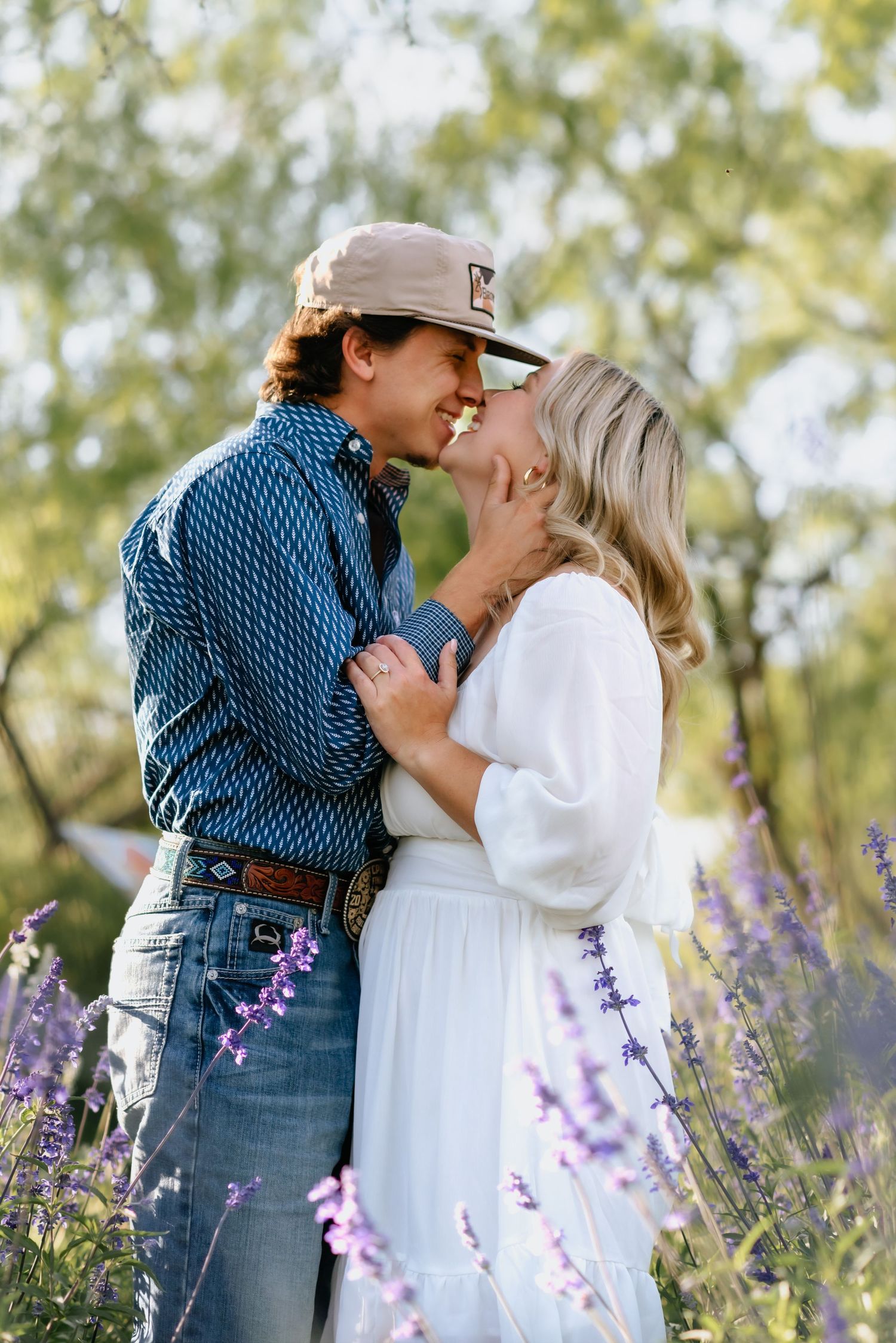 Romantic moment captured in blooming lavender field during golden hour.