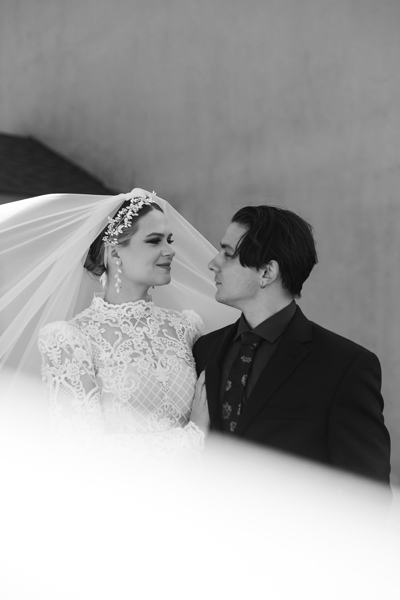 Artistic black and white portrait of a couple in wedding attire.