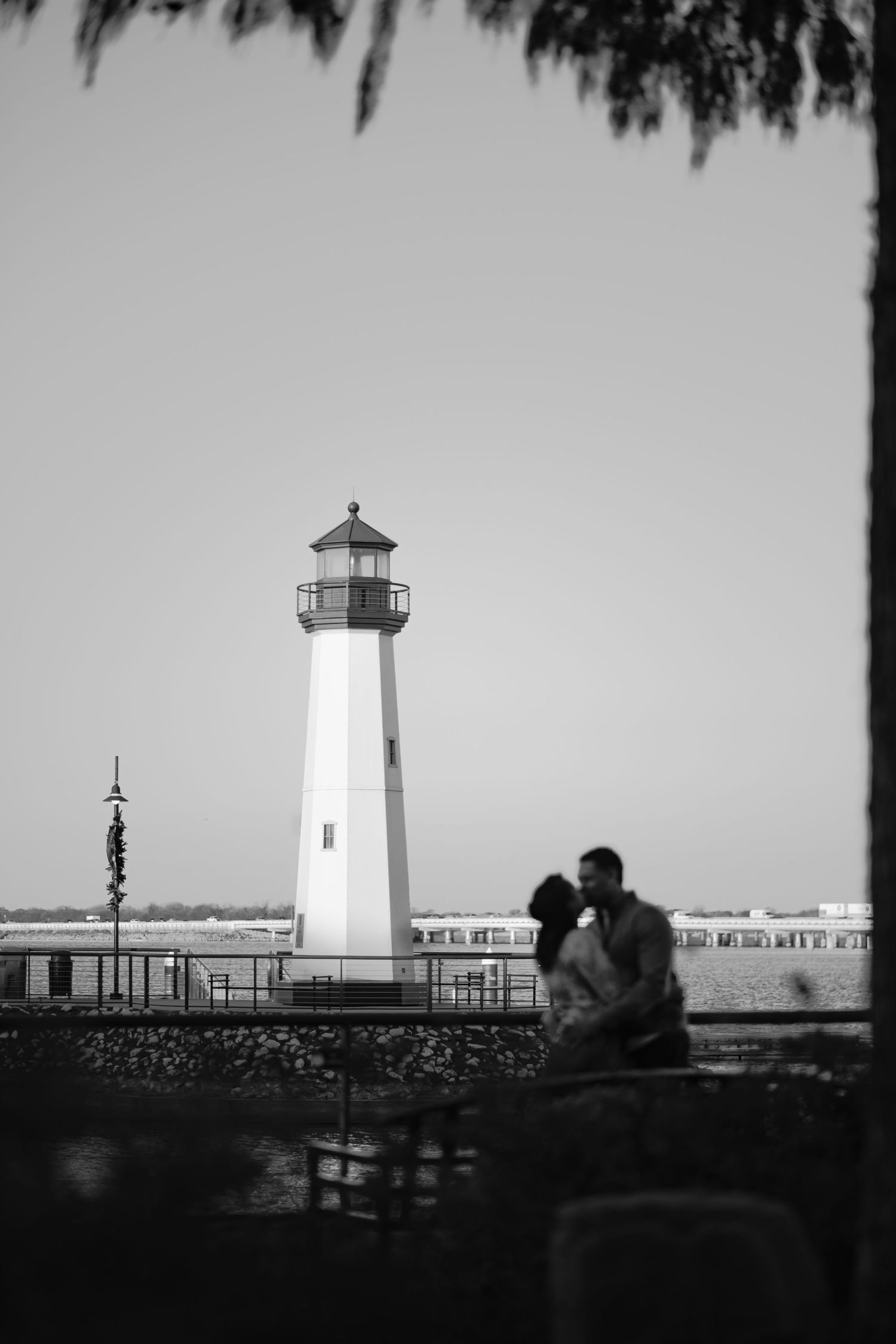 Lighthouse silhouettes at sunset create a dramatic panoramic series of black and white photographs.