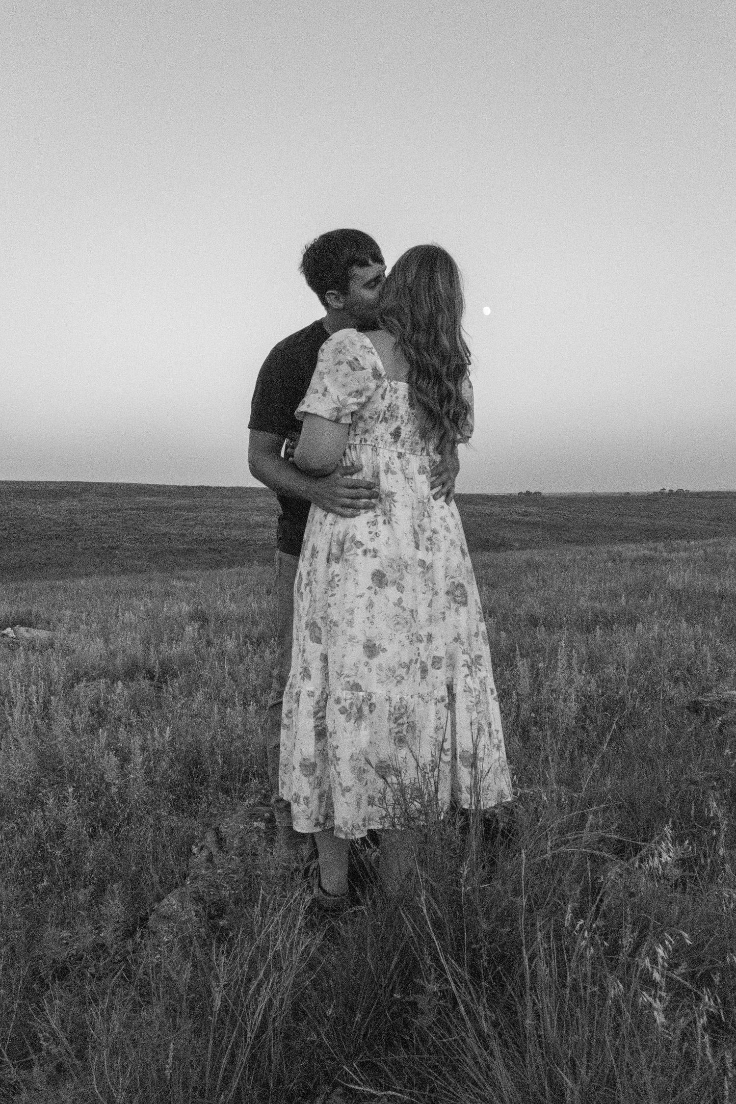 A couple shares an intimate moment in a pasture in Kansas.