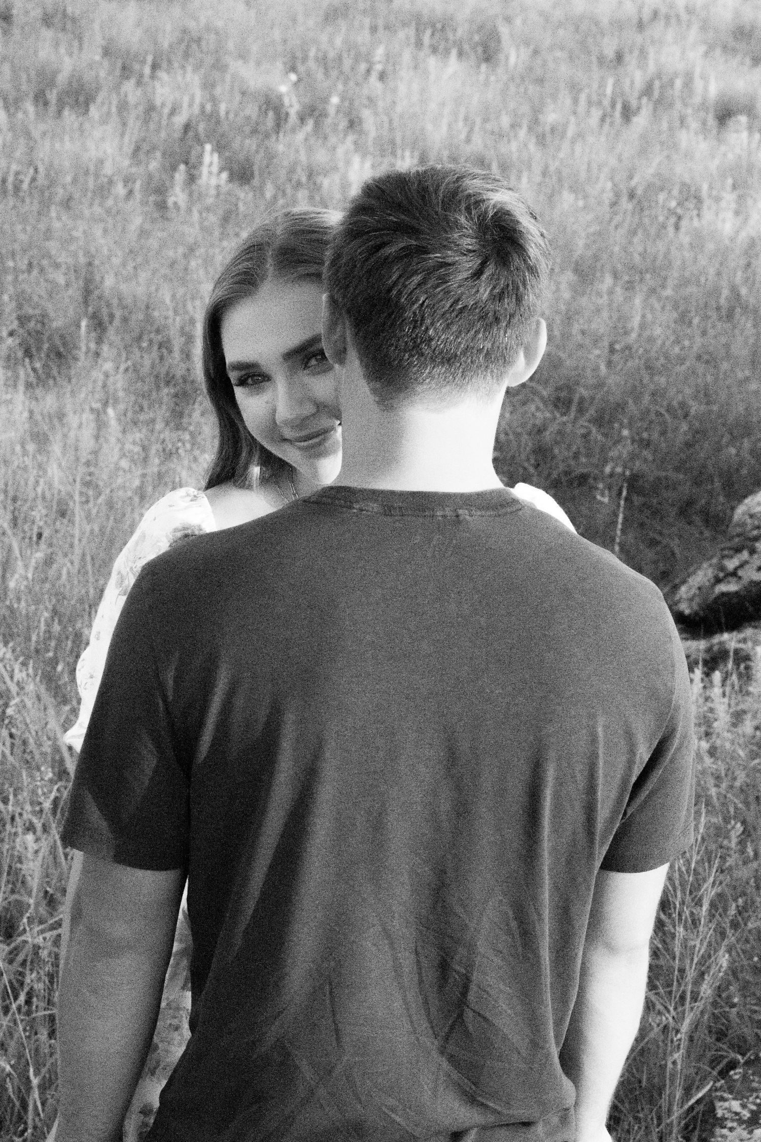 A woman looks over her boyfriend's shoulder during a couples session.