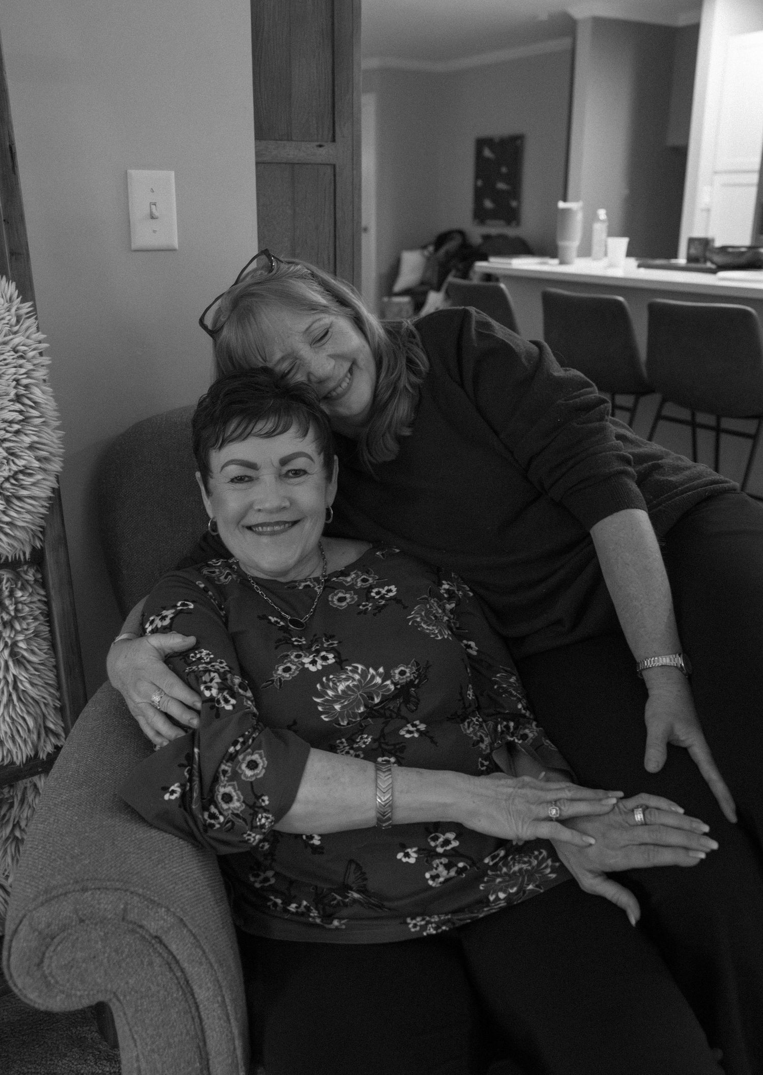Two people sharing a warm embrace while relaxing on a cozy couch.