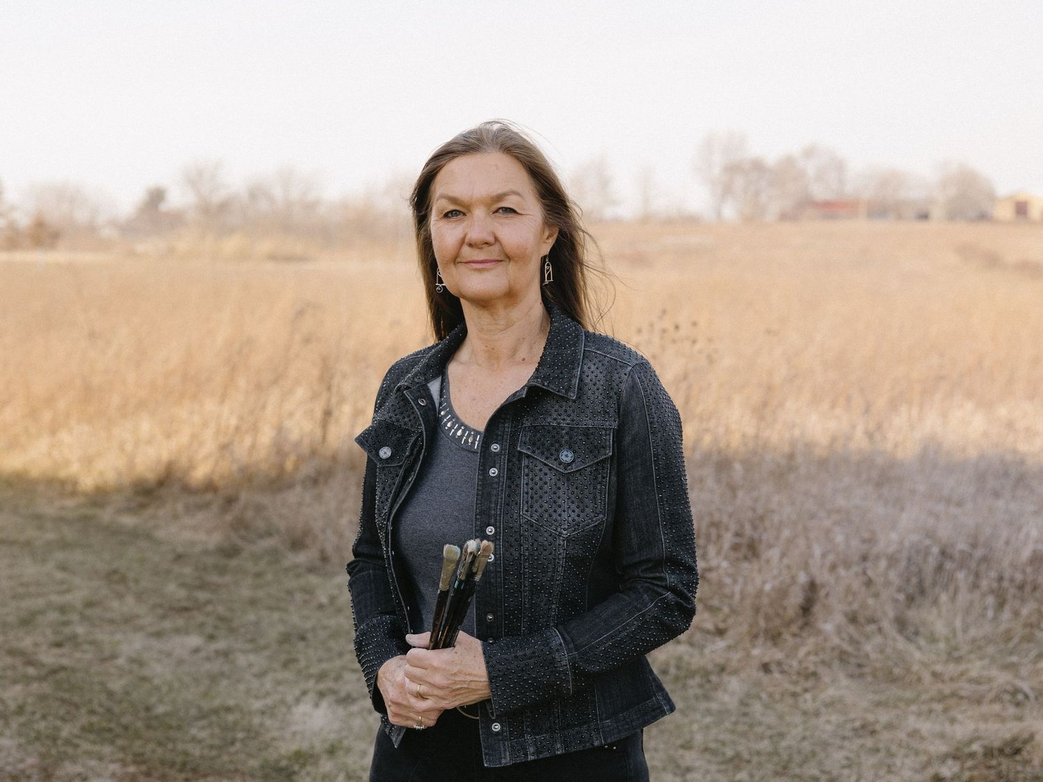 A scenic portrait taken in a field of tall grass during golden hour.