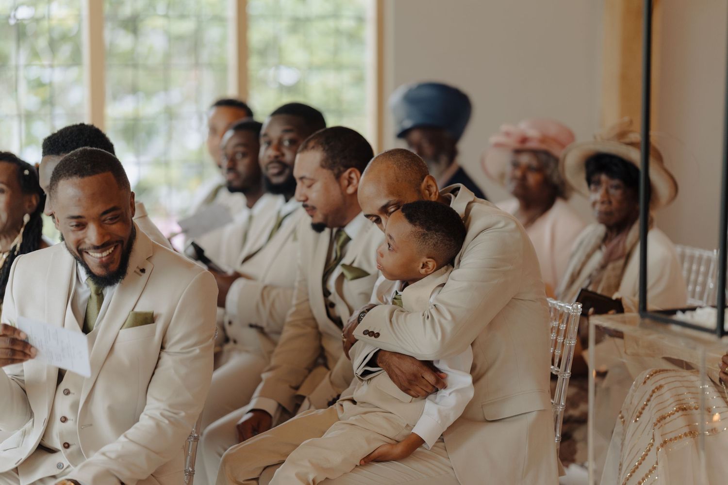Guests in formal attire share laughter during a wedding celebration.