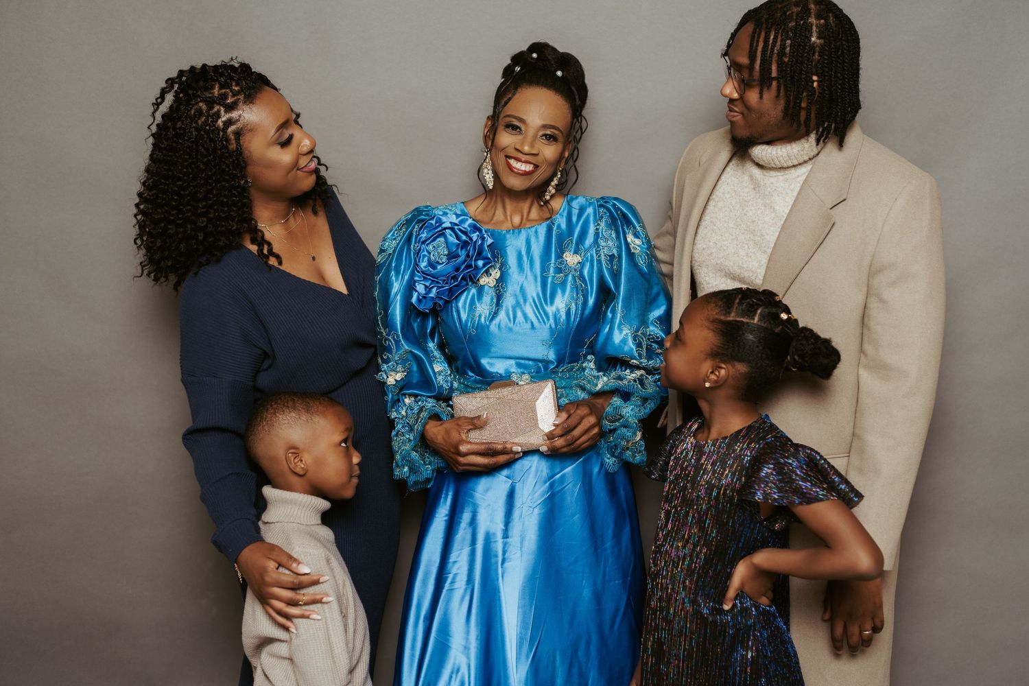 A group poses for a portrait with someone wearing a striking blue dress in the center.