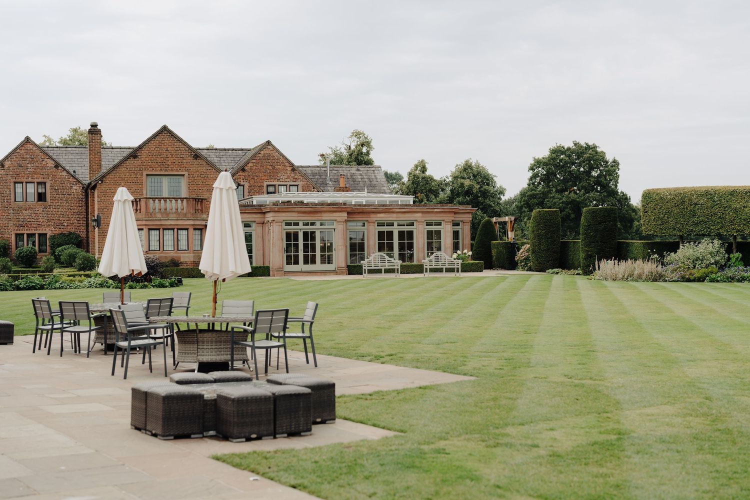 Panoramic view of a wedding venue's outdoor space with manicured lawns and patio furniture.