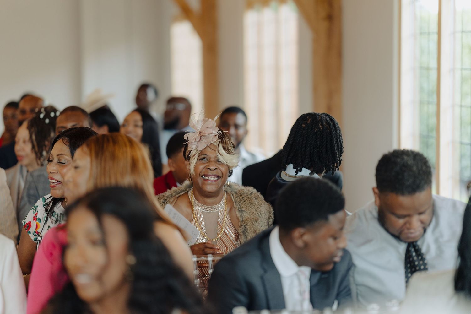 Wedding guests celebrate and interact during a lively indoor reception.