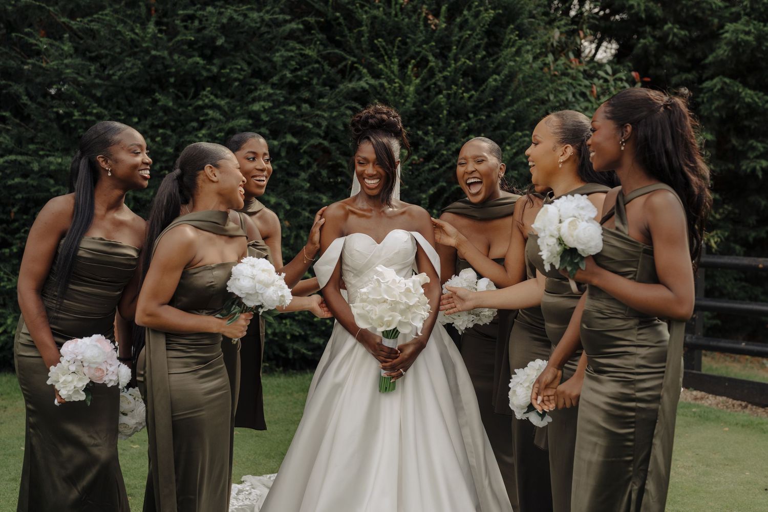 Bridesmaids in brown dresses pose together during wedding celebrations.